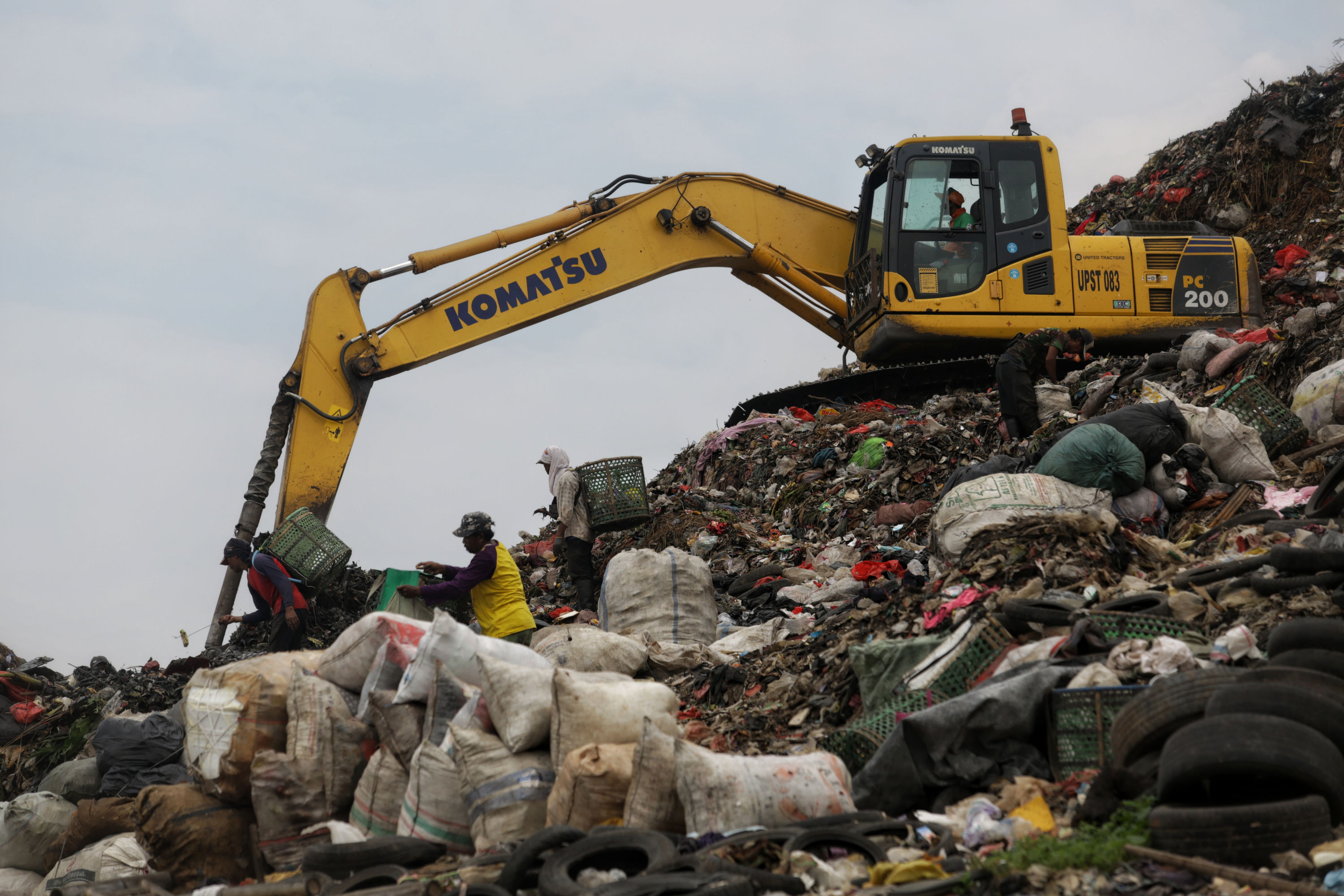 Alat berat menaikan timbunan sampah di TPST Bantar Gebang, Jawa Barat.