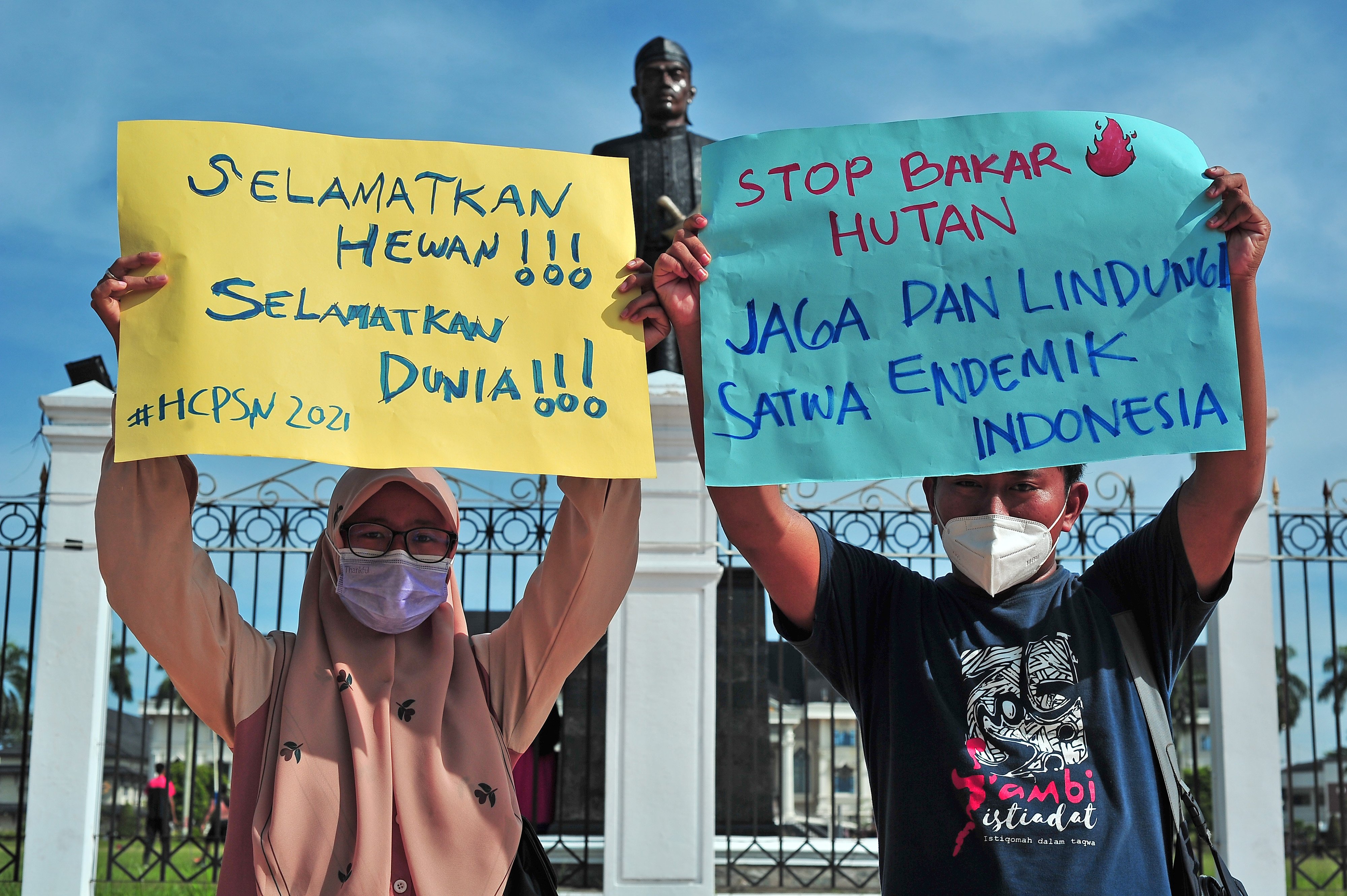 Ilustrasi--Dua demonstran membawa poster berisi slogan.