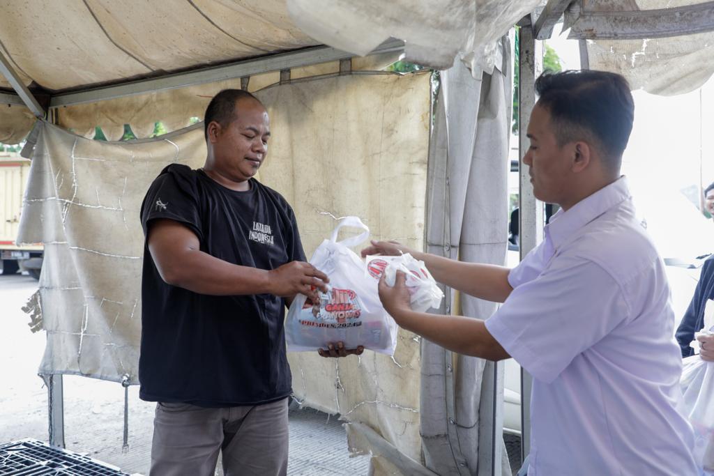 Komunitas Sopir Truk DKI Jakarta membagikan paket sembako kepada warga dan sopir truk di kawasan Kosambi, Jakarta Barat, Rabu (19/10).