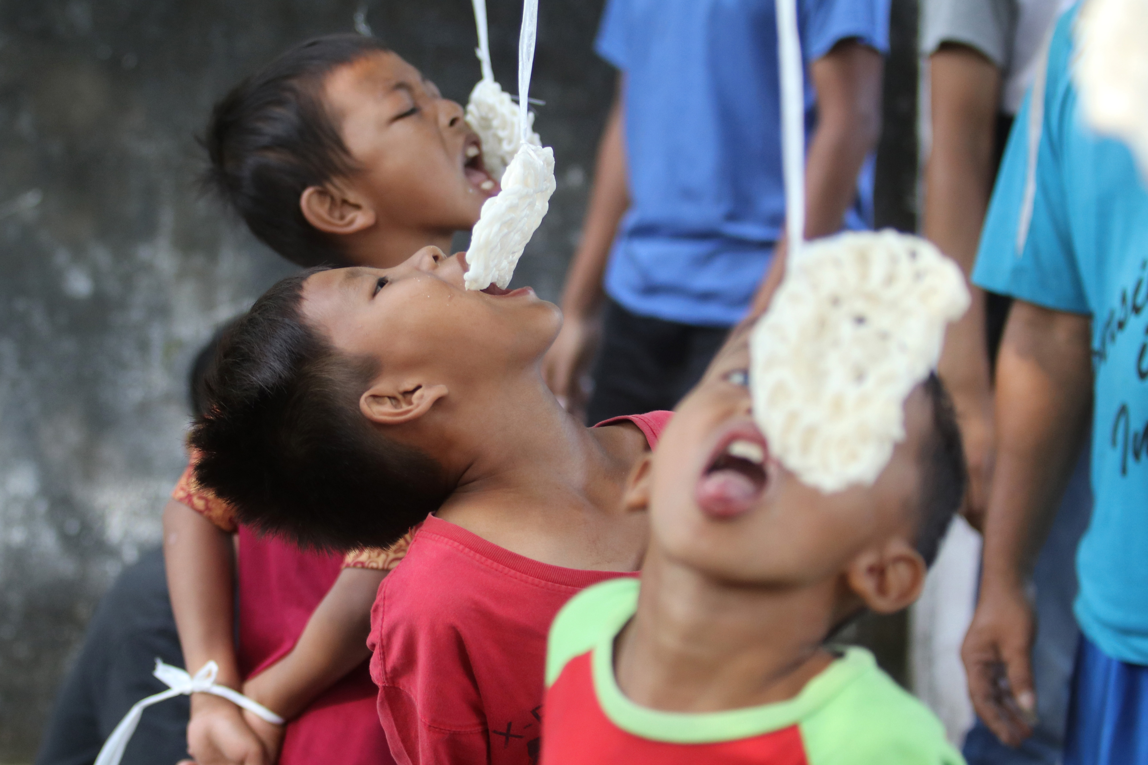 Ilustrasi--Tiga anak bersaing dalam lomba makan kerupuk di peringatan HUT Kemerdekaan RI.