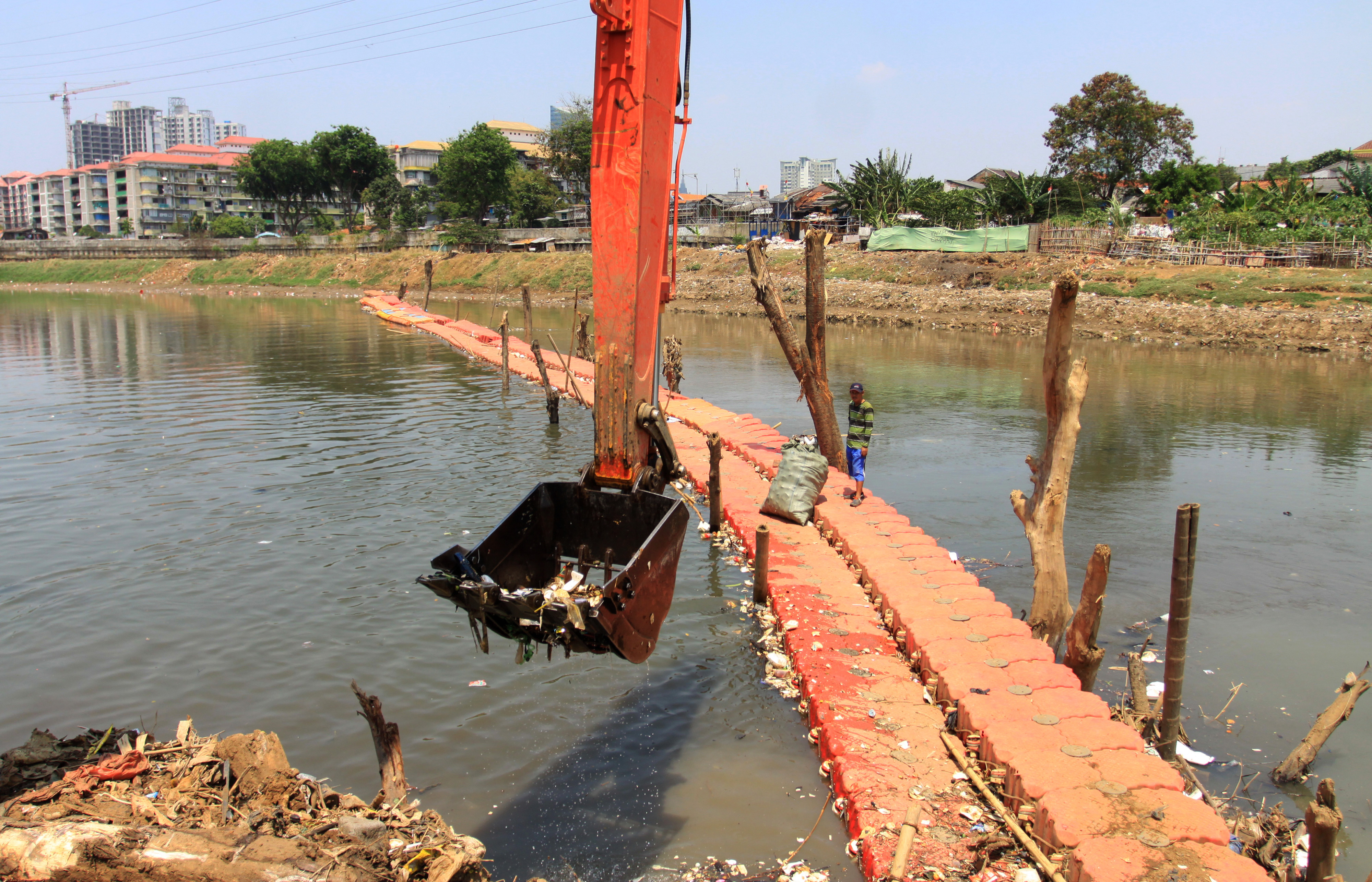 Alat berat melakukan pengerukan lumpur di Kali Ciliwung, Jakarta.