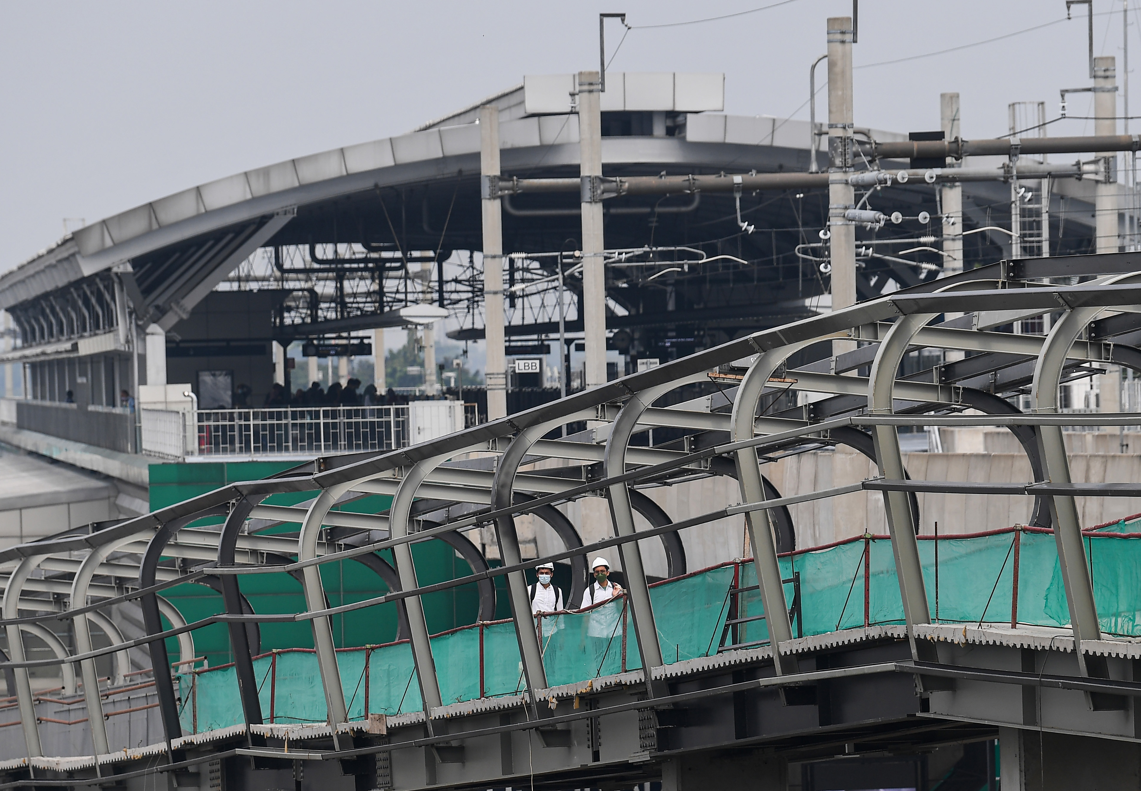 Pekerja melintas di proyek pembangunan transportasi publik di Jakarta.