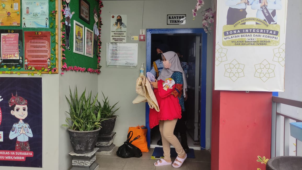 AV, 32, warga binaan yang melahirkan di Rutan Kelas I Surabaya, Jawa Timur bebas setelah mendapatkan asimilasi.