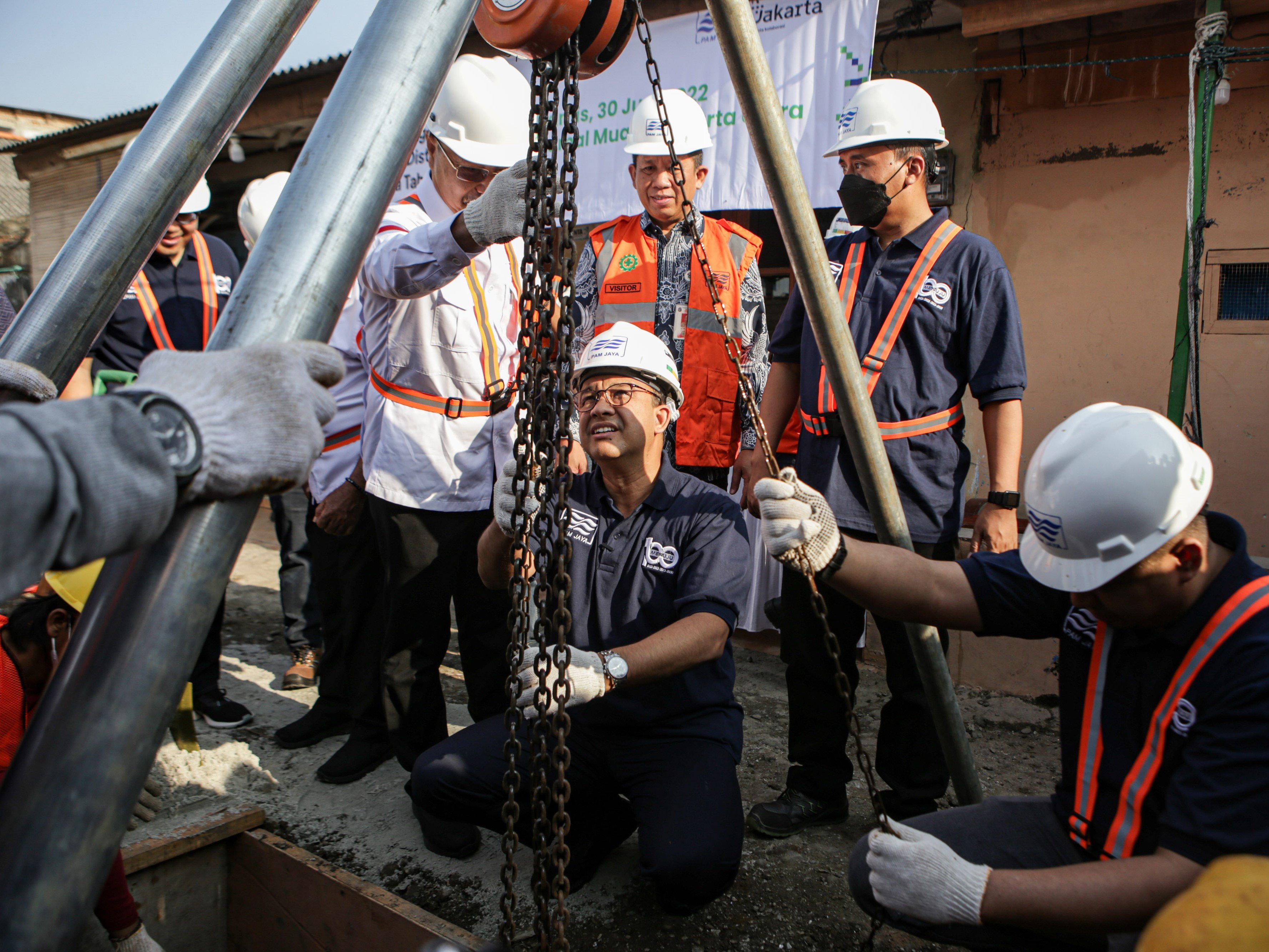 Gubernur DKI Jakarta Anies Baswedan (tengah) melakukan peletakan pipa distribusi tahap dua saat kegiatan Hajatan 100 Hari Air Mengalir.