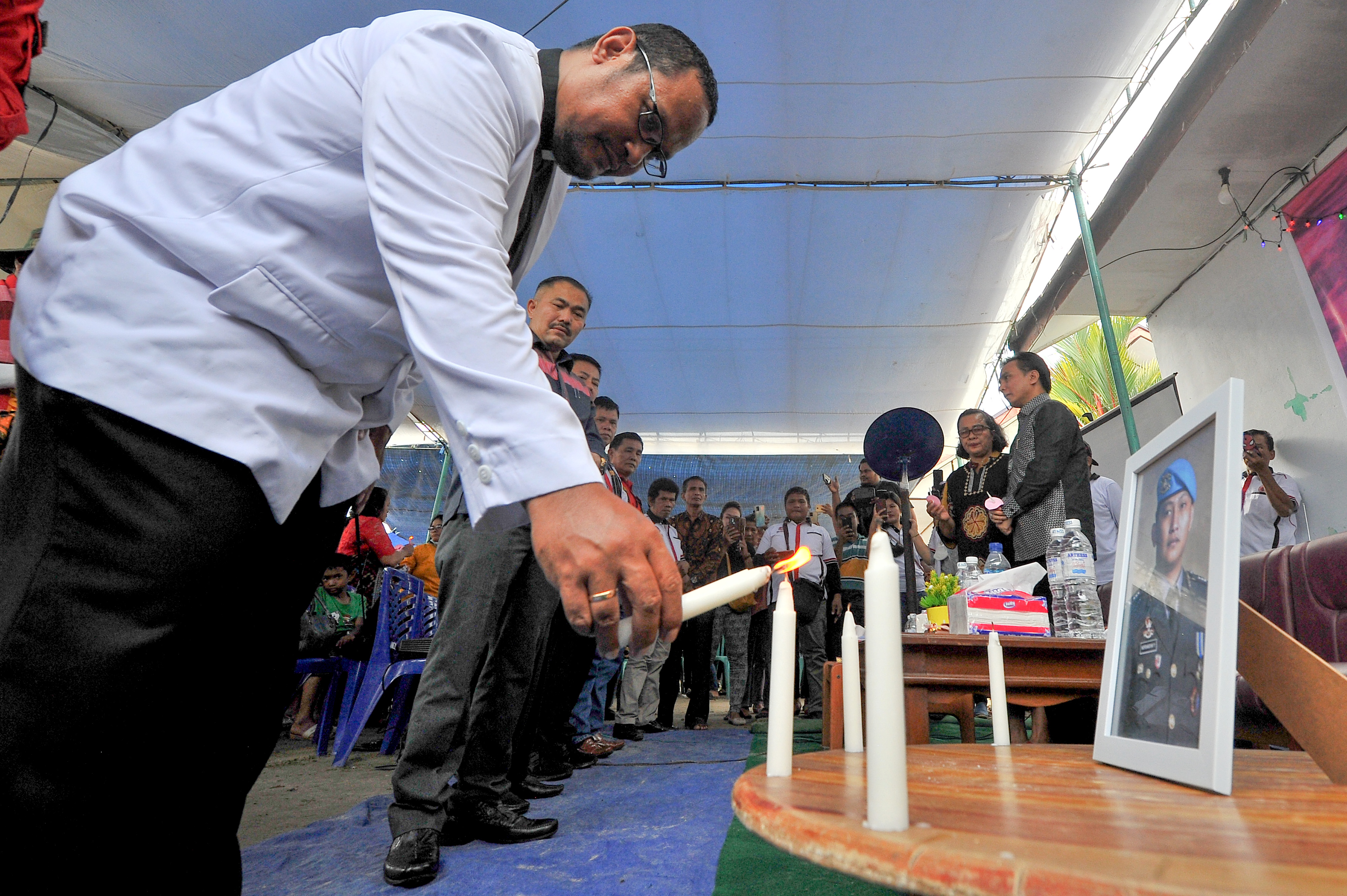 Pemuka agama menyalakan lilin disaksikan keluarga dan kuasa hukum mendiang Brigadir J saat mengenang 100 hari kematian Brigadir J, 15/10.