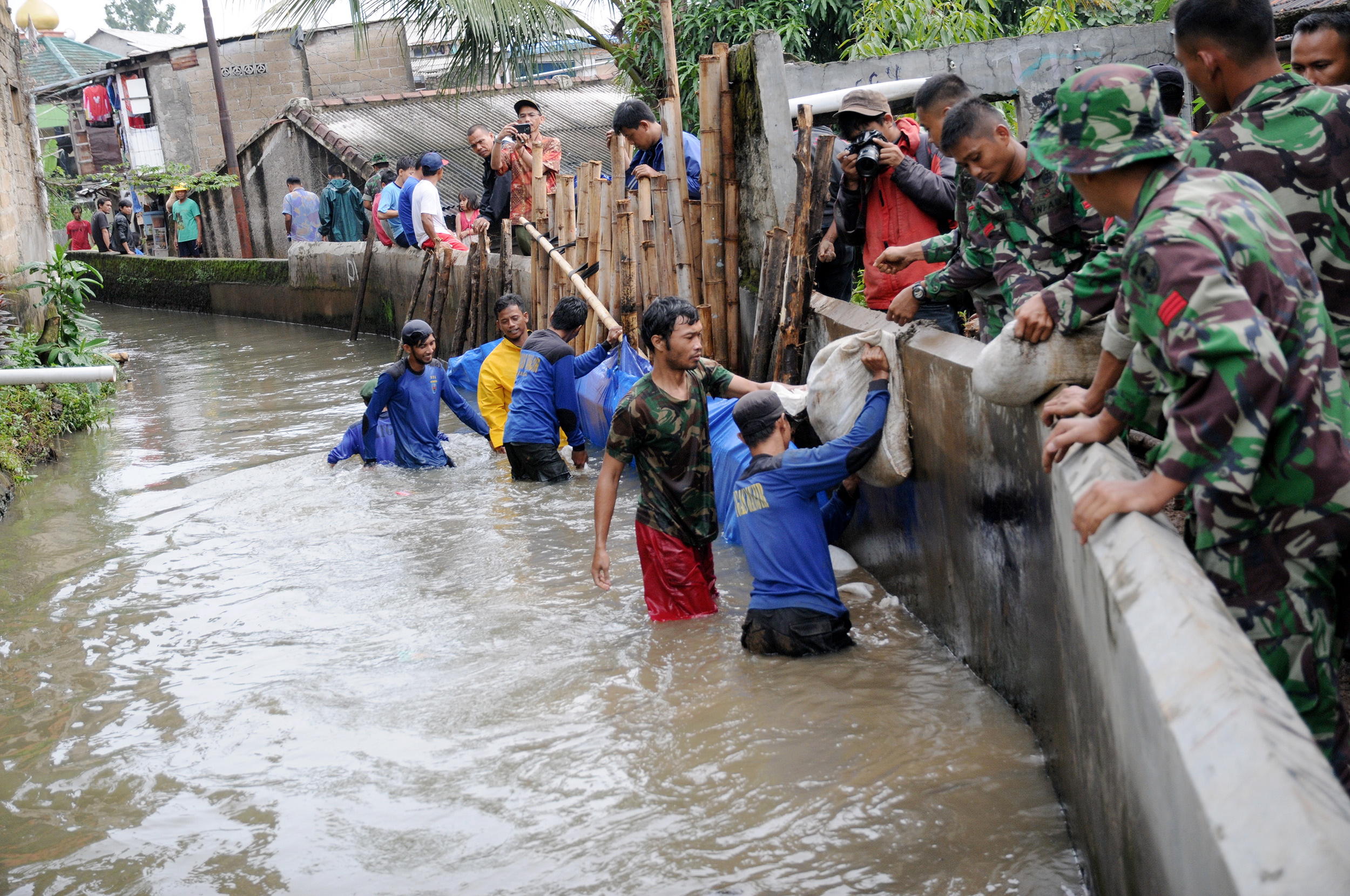 Prajurit TNI dari Kodim 0508 Kota Depok dan Satgas Banjir menambal tanggul Kali Laya yang jebol di RT 11/RW 12, Cimanggis, Depok, Jawa Barat