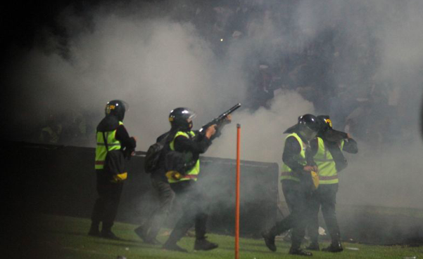 Aparat keamanan menembakkan gas air mata untuk menghalau suporter yang masuk ke lapangan, di Stadion Kanjuruhan, Malang, Jawa Timur.