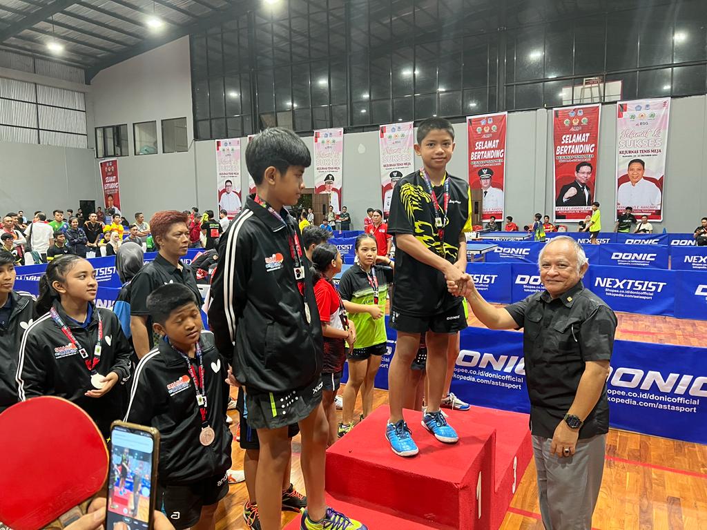 Wakil Sekjen II Bidang Hukum KONI Pusat Markus Othniel Mamahit mengalungkan medali emas kepada tim Jawa Barat.