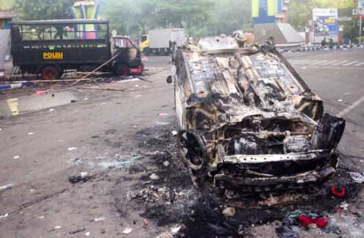 Foto ini menunjukkan kendaraan yang dibakar di luar stadion Kanjuruhan, Malang, Jawa Timur, Minggu 2 Oktober 2022.