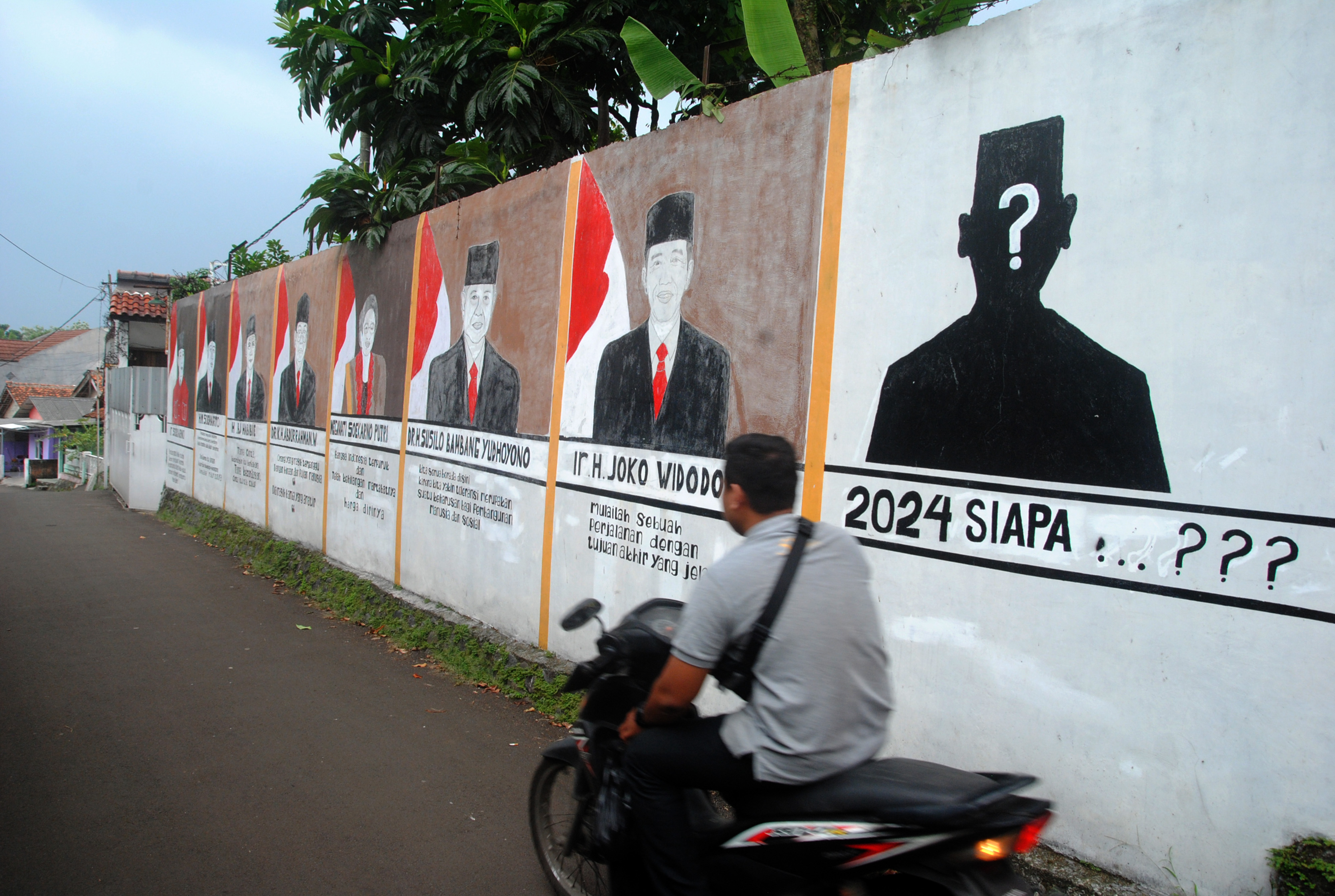 Warga melintasi mural terkait pemilu.