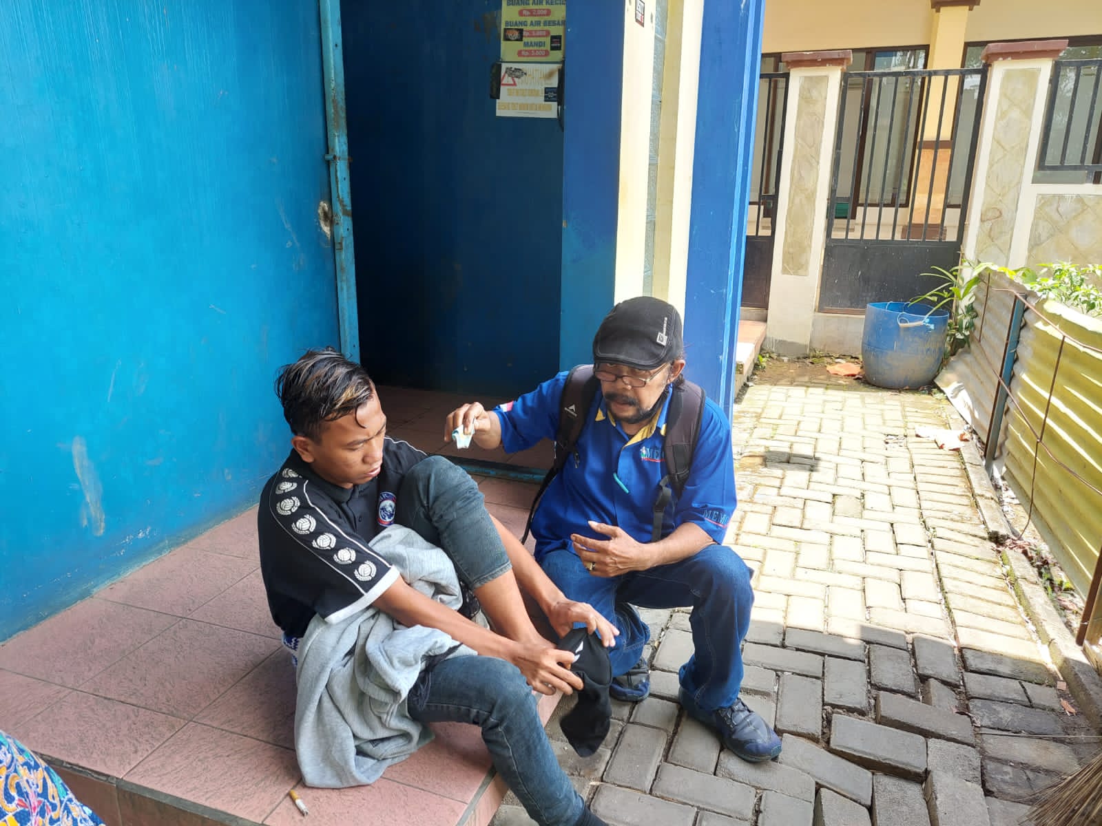 R (kiri) yang menginap di Stadion Kanjuruhan karena menunggu ketiga temannya yang tak kunjung ditemui