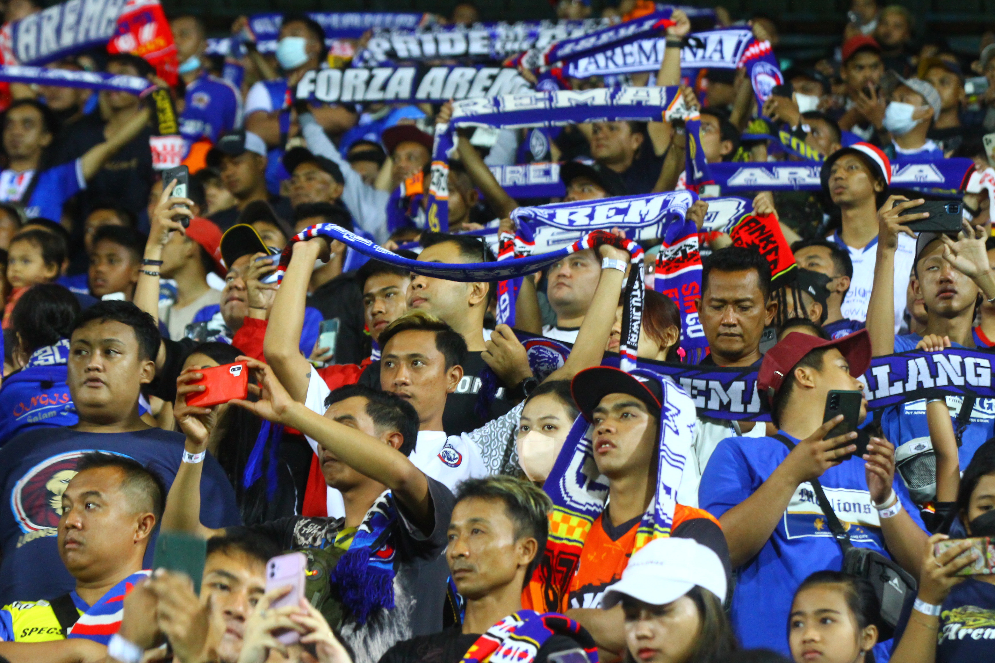 Potret suporter Arema FC, atau biasa disebut Aremania, saat memberikan semangat kepada tim kesayangannya.