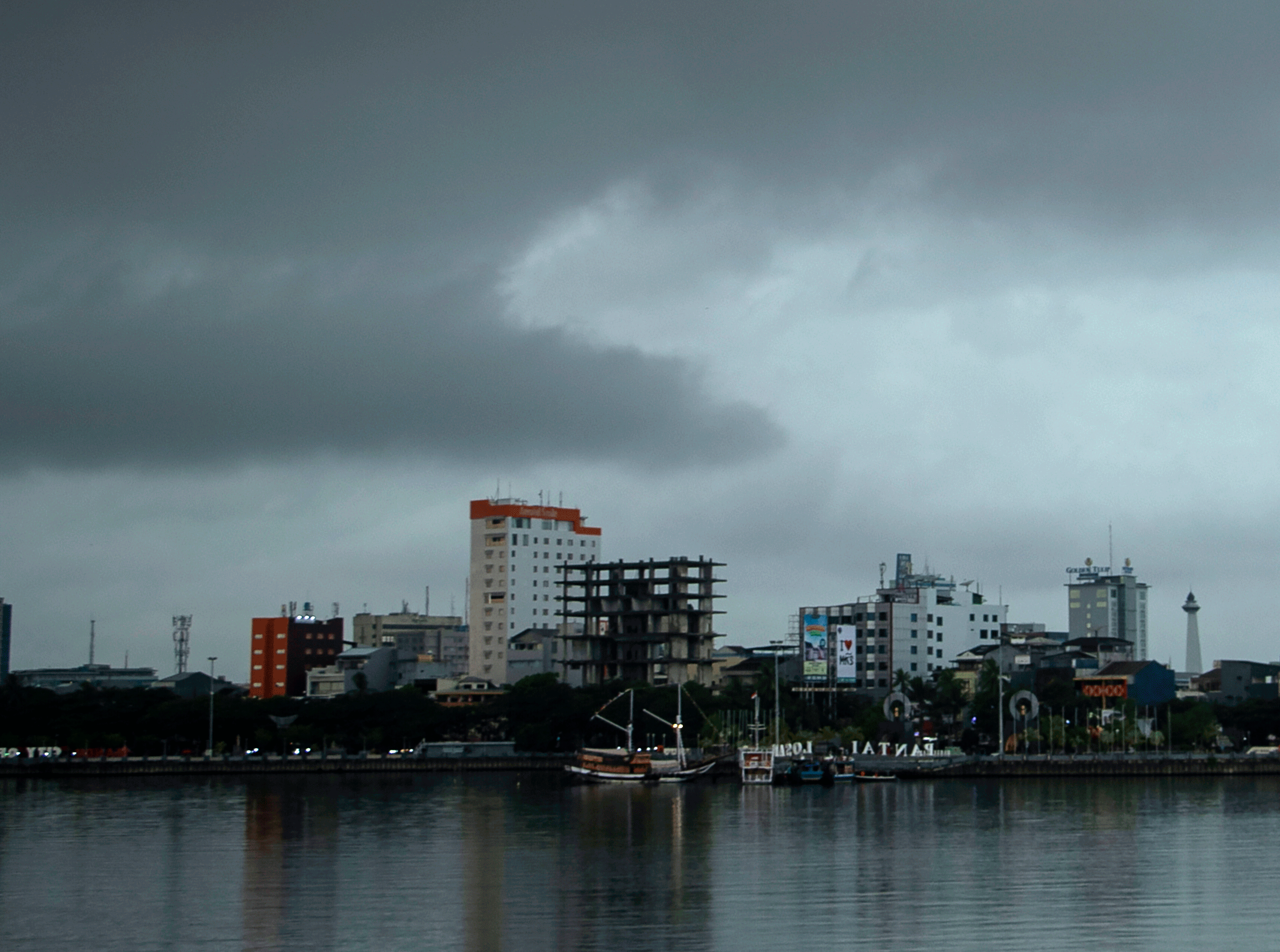 Suasana gedung bertingkat saat awan hitam menggelanyut di langit kota Makassar, Sulawesi Selatan, Sabtu (22/10/2022).