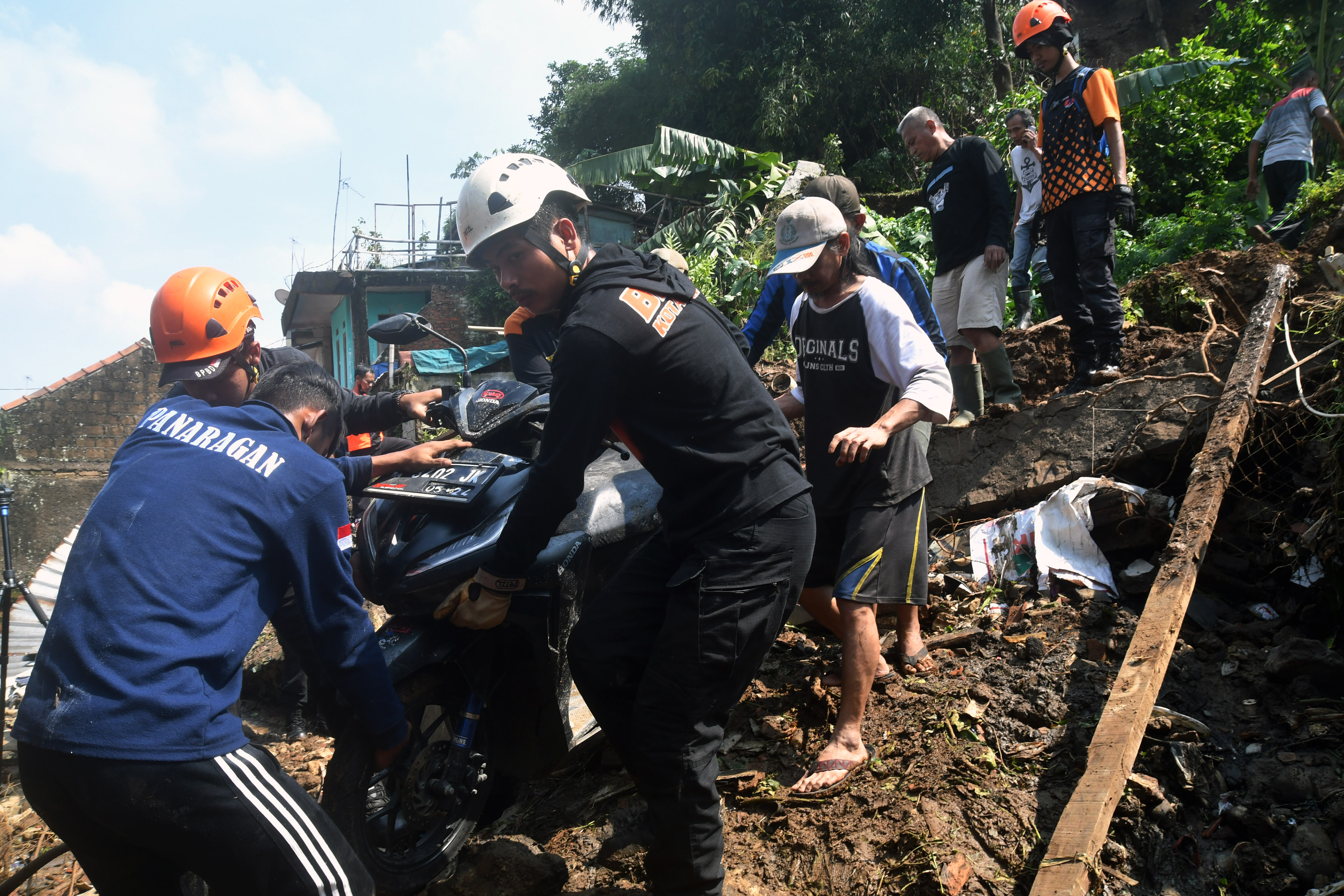 Petugas BPBD Kota Bogor bersama warga mengevakuasi sepeda motor yang tertimpa longsor di Kelurahan Kalapa, Bogor, Jabar, Rabu (12/10).