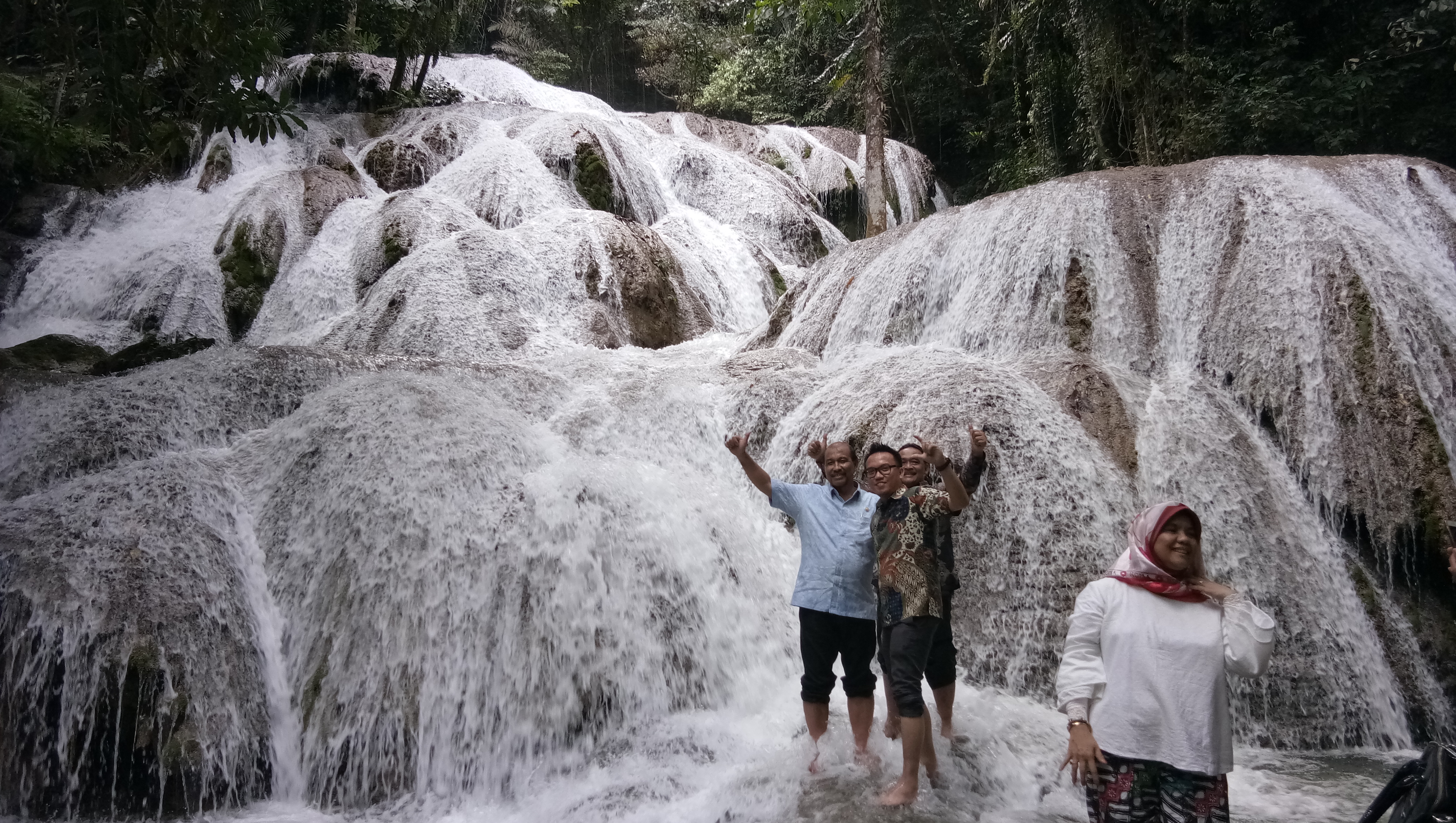 Sejumlah wisatawan berpote dengan latar belakang air terjun Saluopa di Poso, Sulawesi Tengah.
