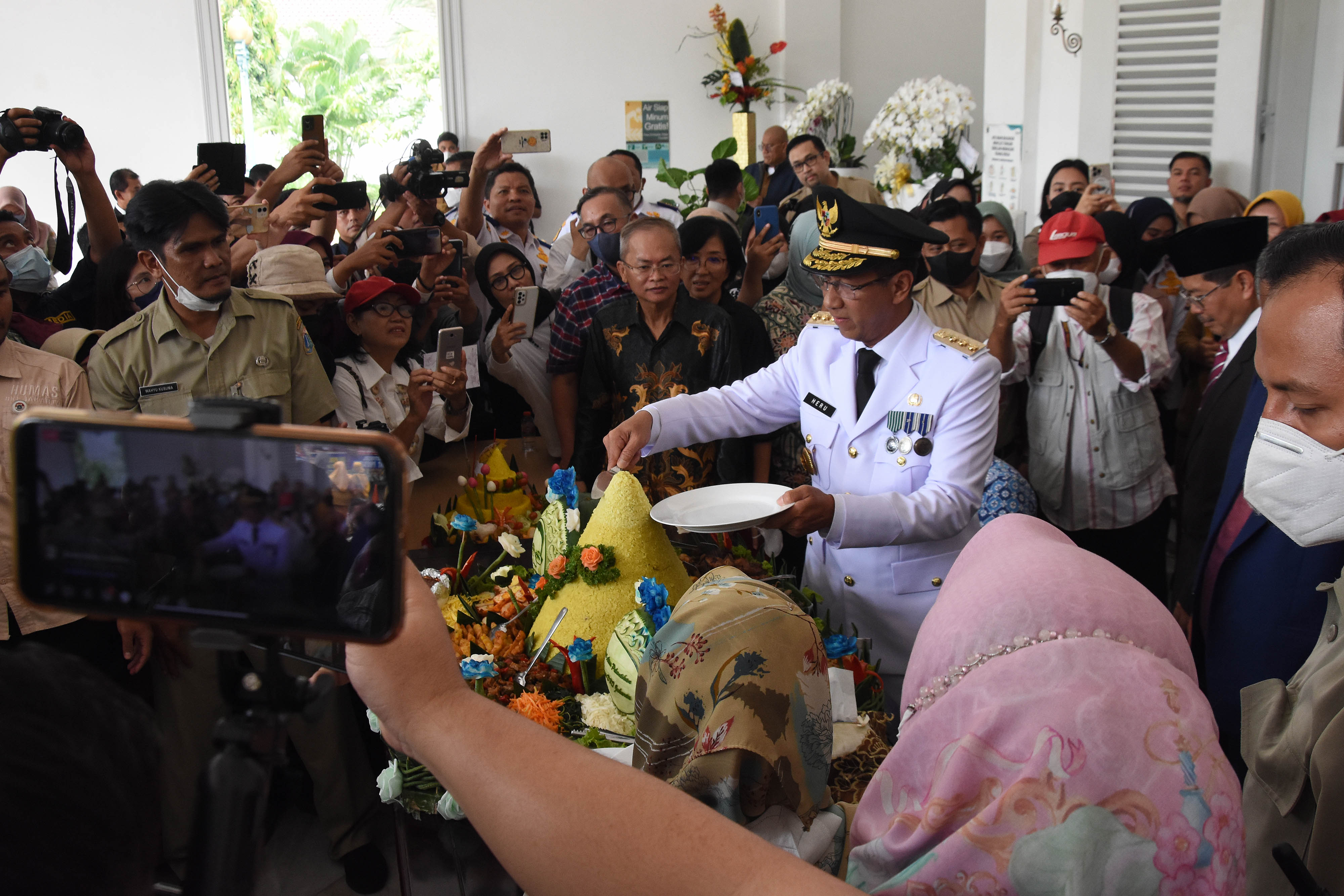 Pj Gubernur DKI Jakarta Heru Budi Hartono saat memotong tumpeng.