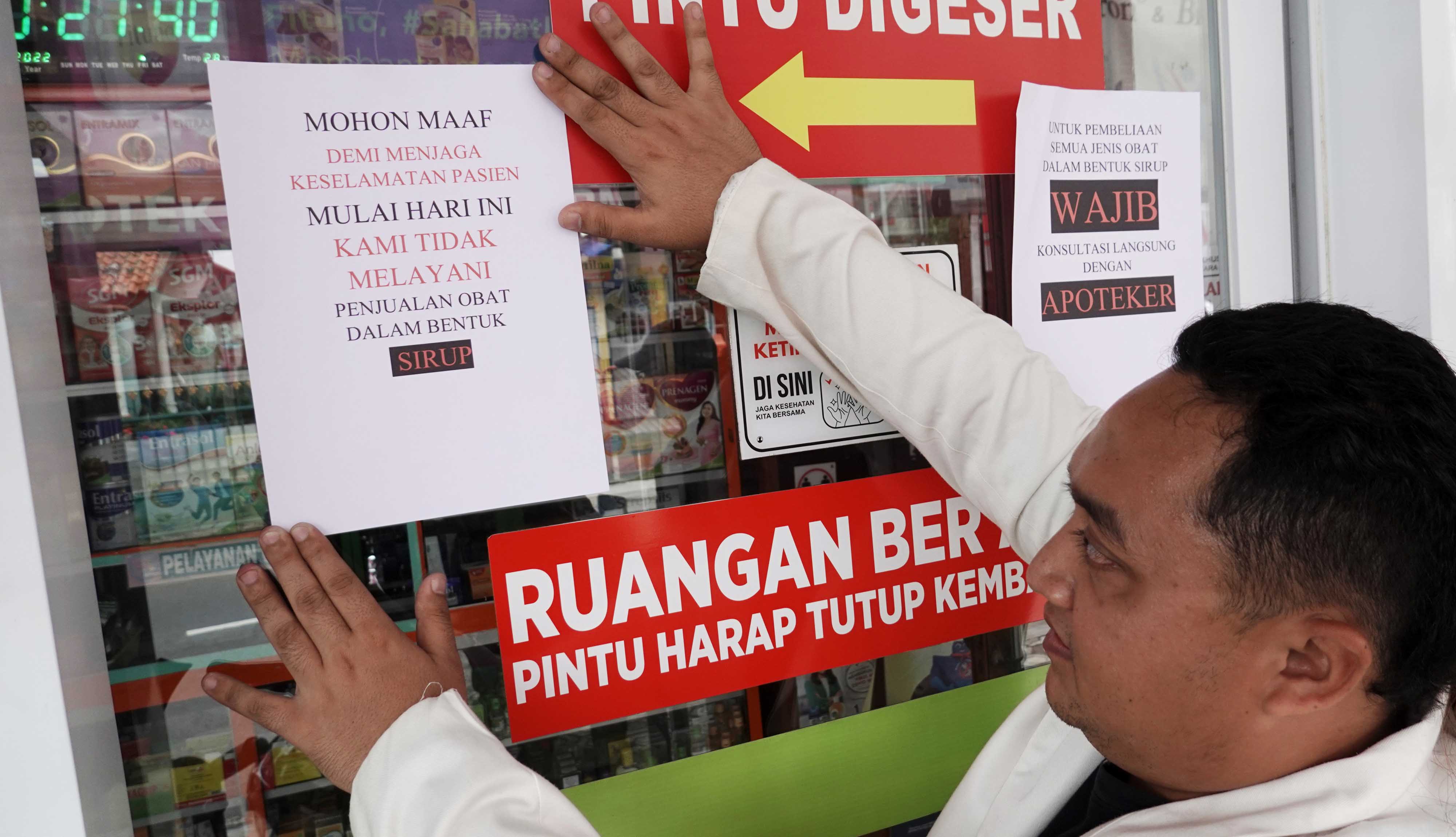 Apoteker memasang pengumuman penghentian penjualan obat sirop di sebuah apotek di Purwokerto, Banyumas, Jawa Tengah, Jumat (21/10).