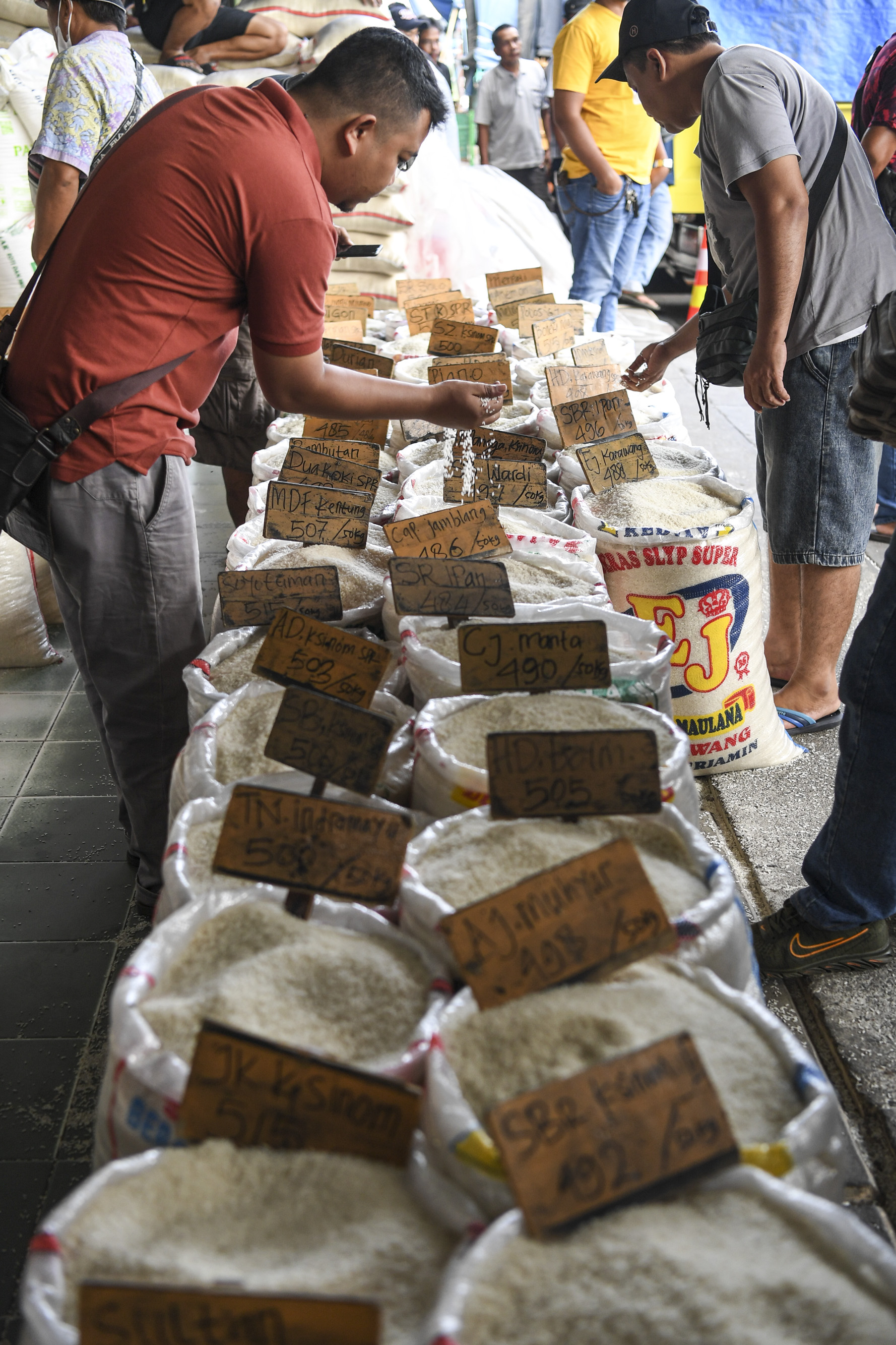Sejumlah calon pembeli mengecek kualitas beras di Pasar Induk Beras Cipinang, Jakarta, Senin (3/10).