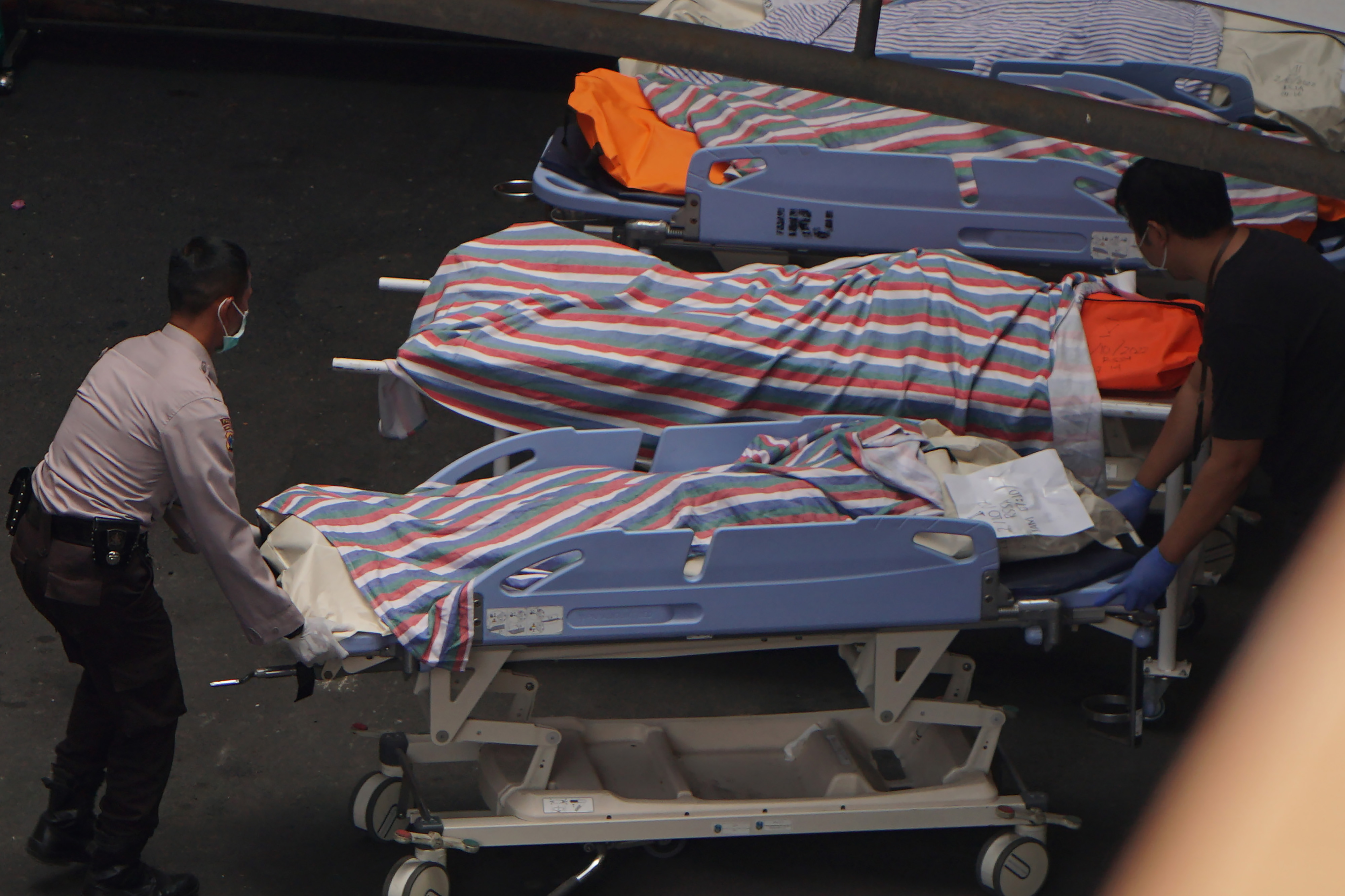 Petugas medis dan polisi memindahkan jenazah korban kerusuhan di Stadion Kanjuruhan, Kabupaten Malang, Jawa Timur, Minggu (2/10).