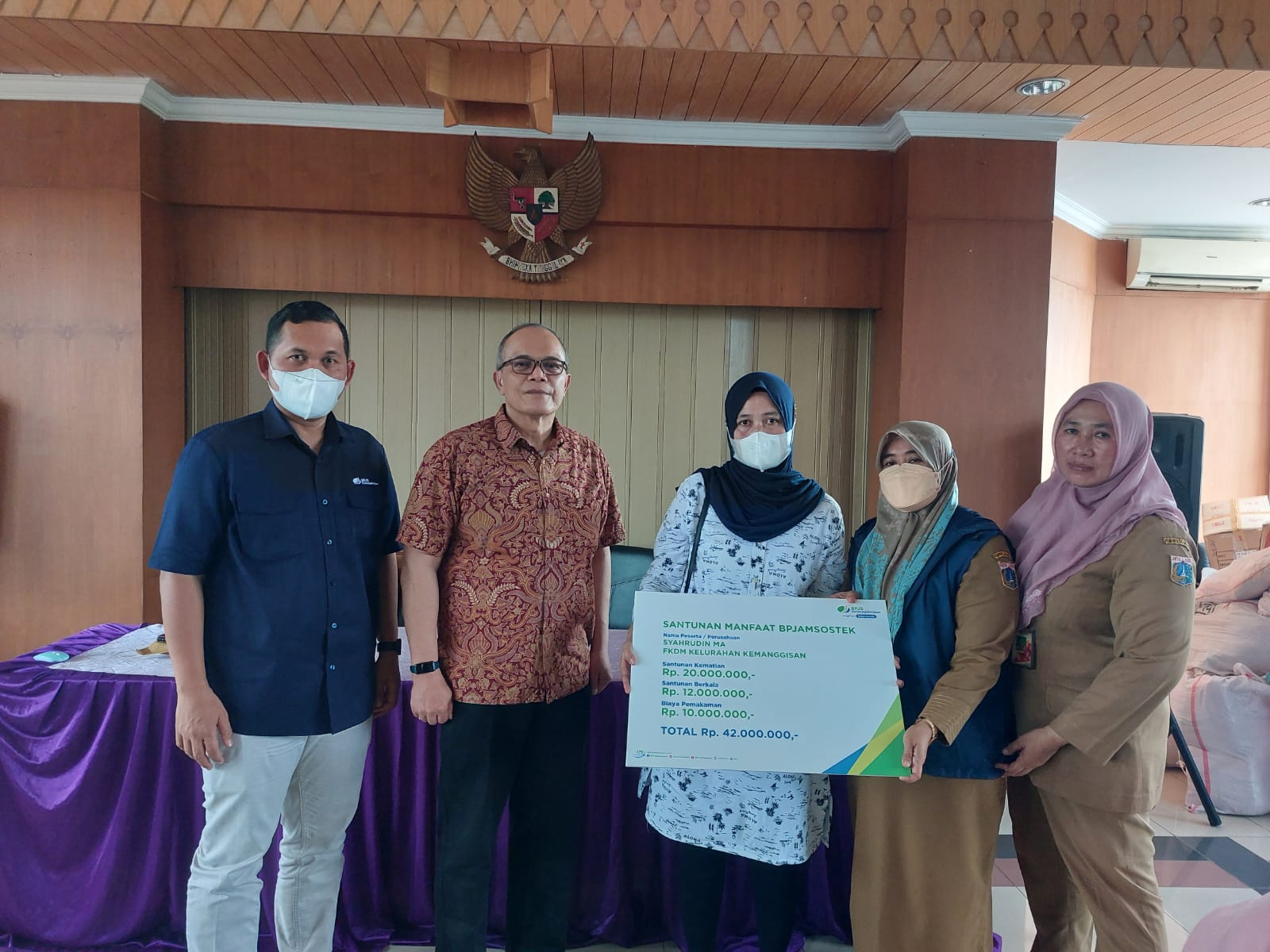 Kepala Kantor Cabang Grha BPJAMSOSTEK Achmad Fatoni menyerahkan santunan kepada ahli waris Syahrudin MA yang diterima Muliyawati. 