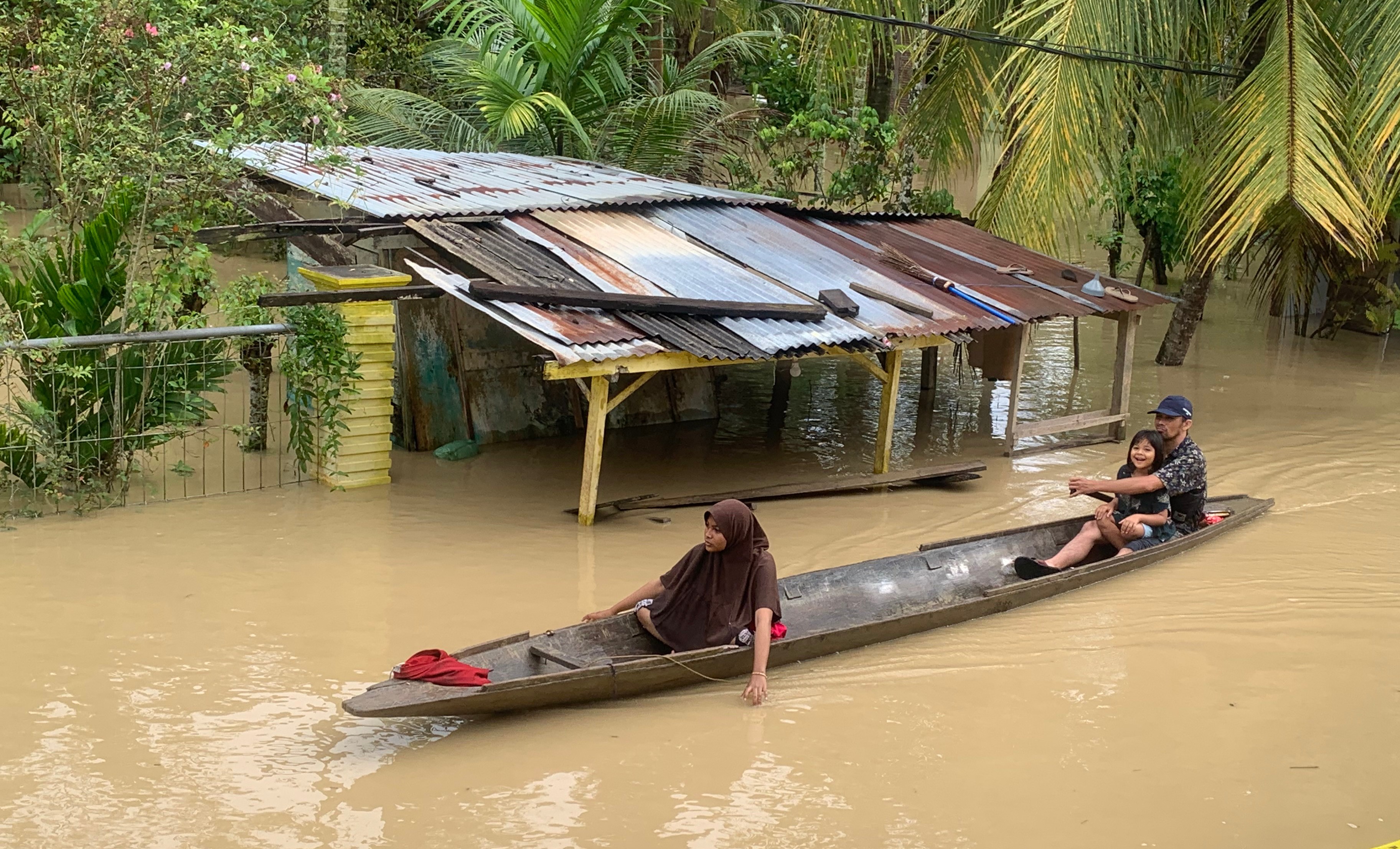 Keluarga menggunakan sampan untuk berpindah ke tempat pengungsian akibat banjir di Aceh Utara, Provinsi Aceh, Selasa (4/10).