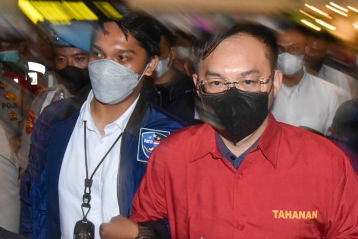 Polisi membawa tersangka bandar judi daring Apin BK (kanan) saat tiba di Bandara Kualanamu, Deli Serdang, Sumut, Senin (17/10/2022)