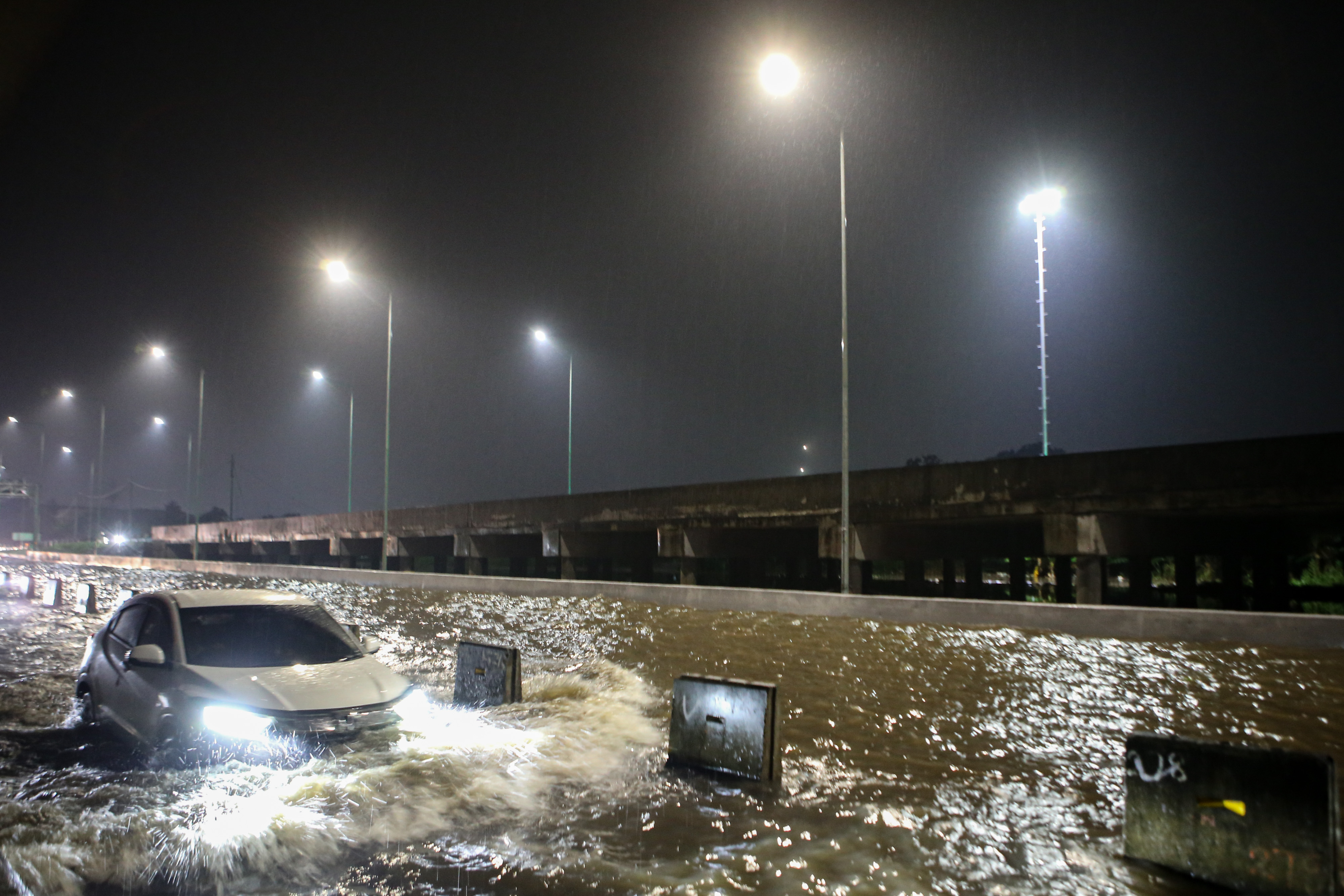 Mobil melintasi banjir di ruas Tol Pondok Aren-Serpong, Kota Tangerang Selatan, Banten, Selasa (4/10).