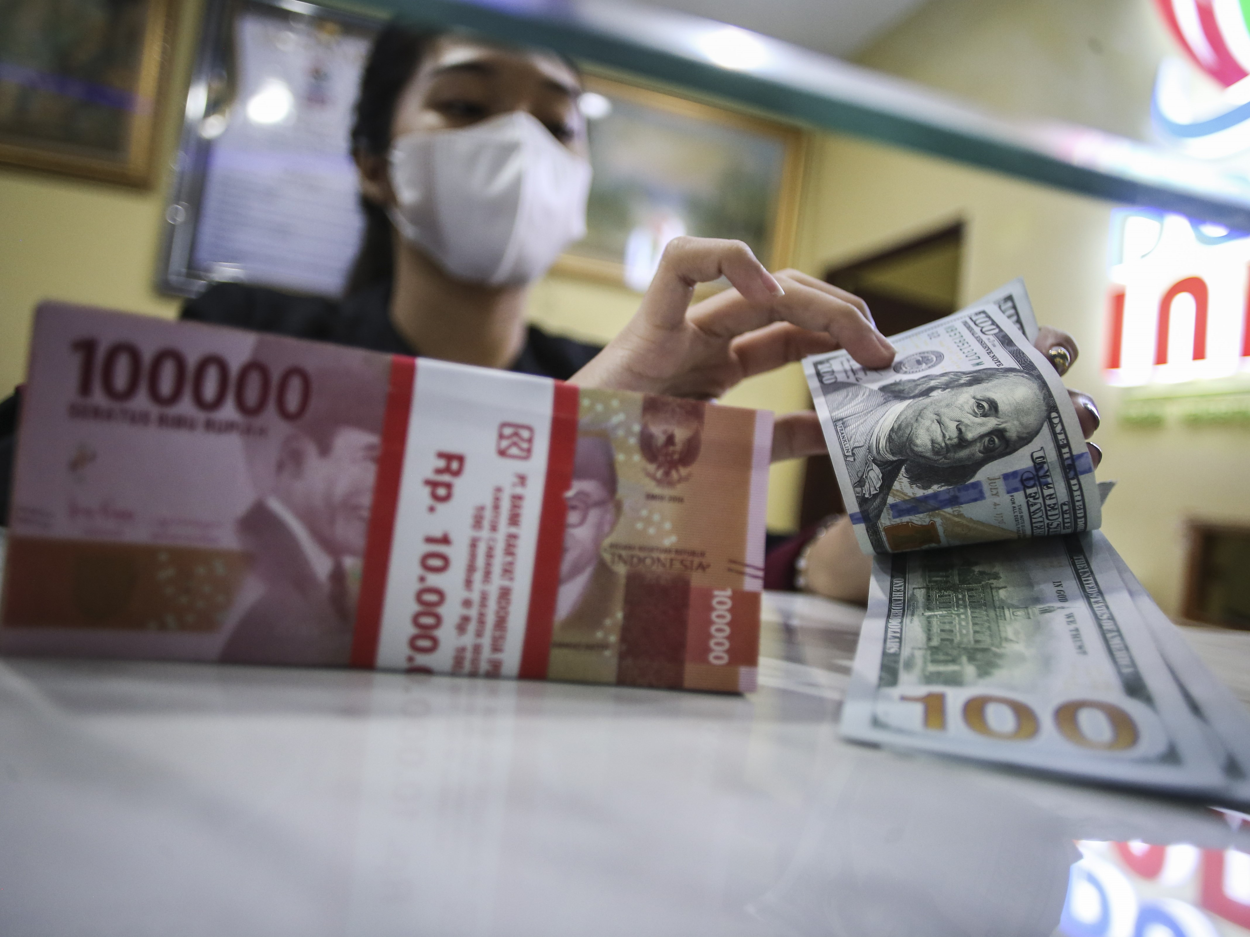 Petugas menghitung pecahan 100 dolar AS di jasa penukaran uang asing Dolar Indo, Melawai, Jakarta, Rabu (28/9/2022). 