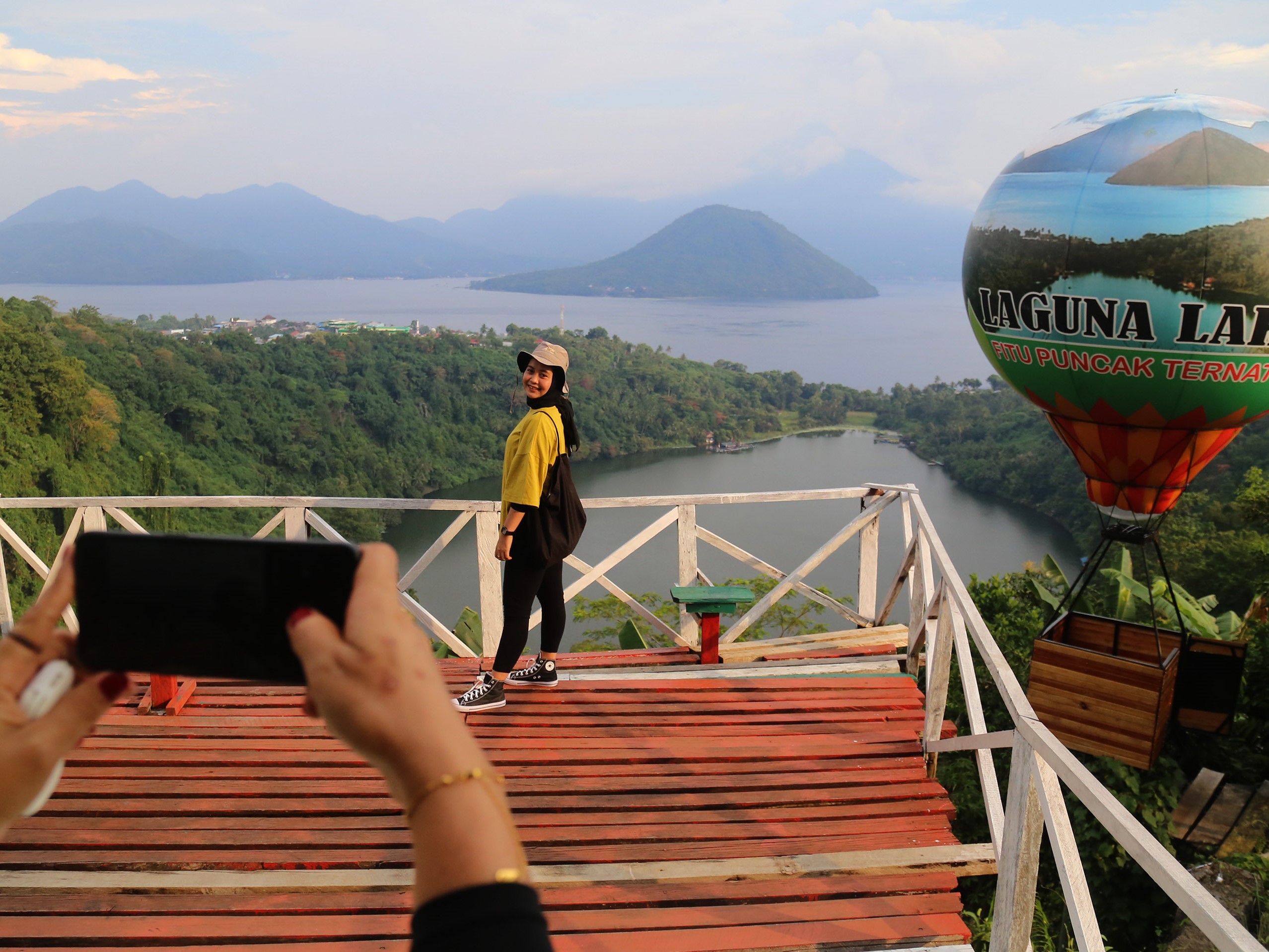 Pengunjung berfoto di objek wisata Danau Laguna Fitu Puncak Ternate, Maluku Utara, Minggu (16/10/2022).