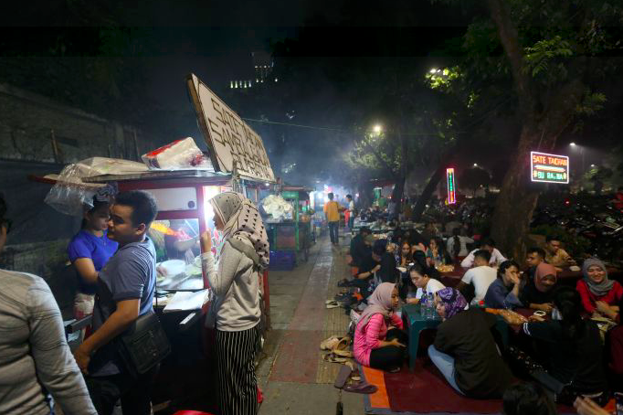 Ilustrasi pedagang sate Taichan menggelar lapak di trotoar Jalan Asia-Afrika di Senayan, Jakarta.