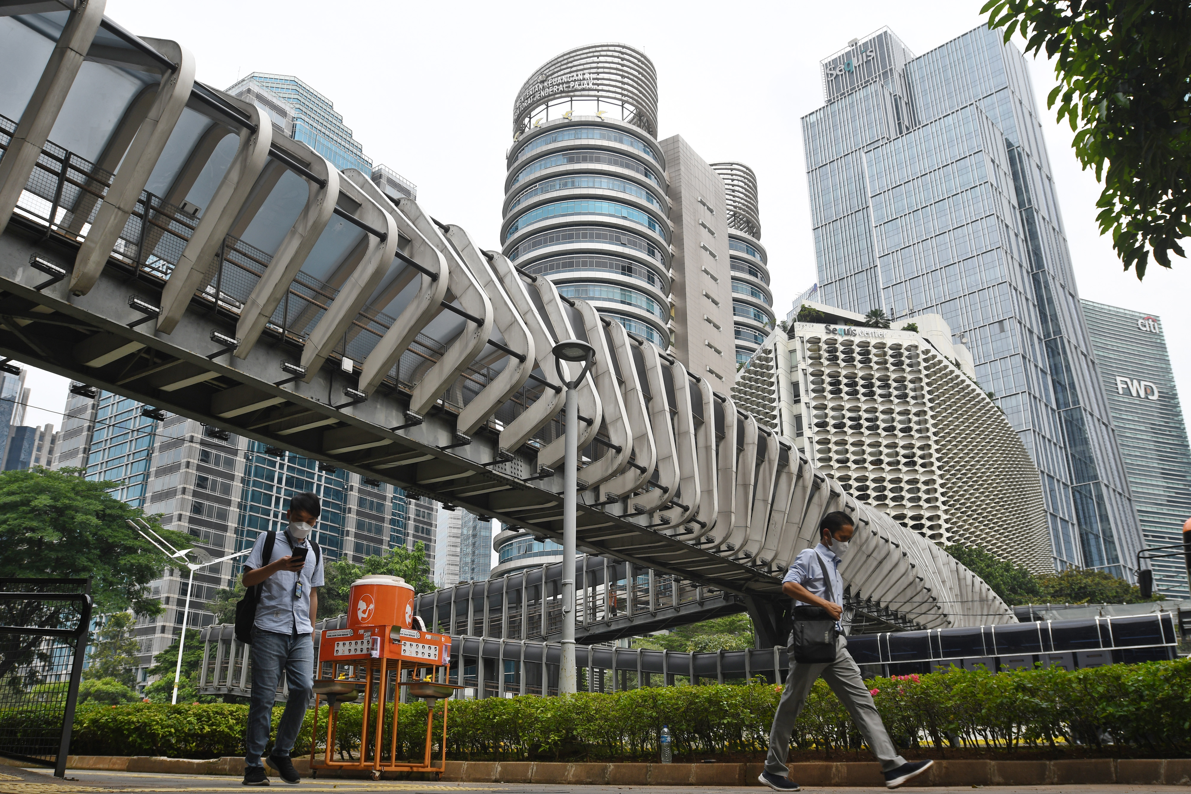 Sejumlah warga berjalan di trotoar kawasan Sudirman, Jakarta.