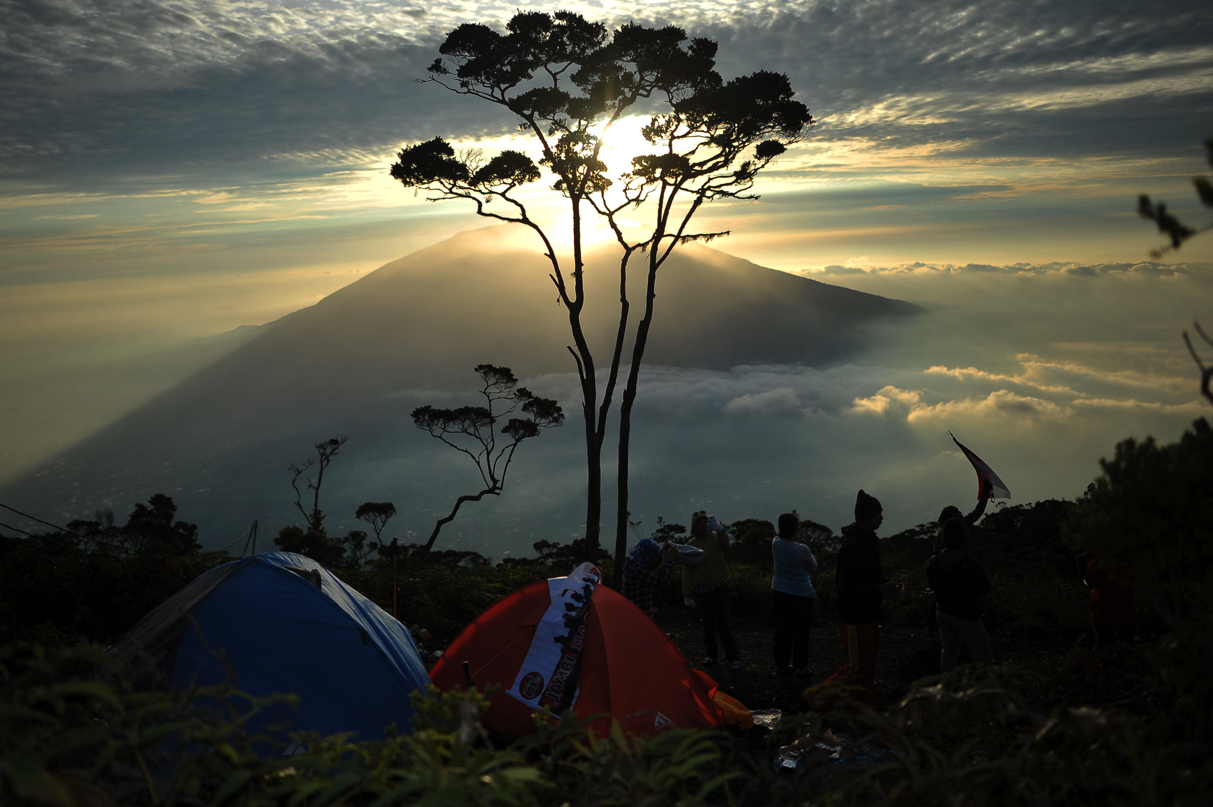 Pendaki berada di Cadas Gunung Singgalang dengan latar belakang panorama Gunung Marapi (2.891 mdpl) di Agam, Sumatra Barat.