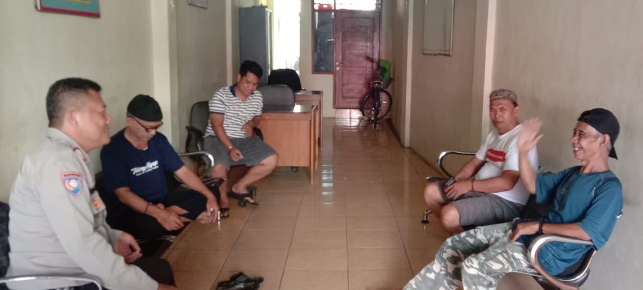 Bhabinkamtibmas Polsek Sawah Besar Bripka Parmuji (kiri) sedang berdiskusi dengan warga Kelurahan Kartini, Sawah Besar, Jakarta Pusat