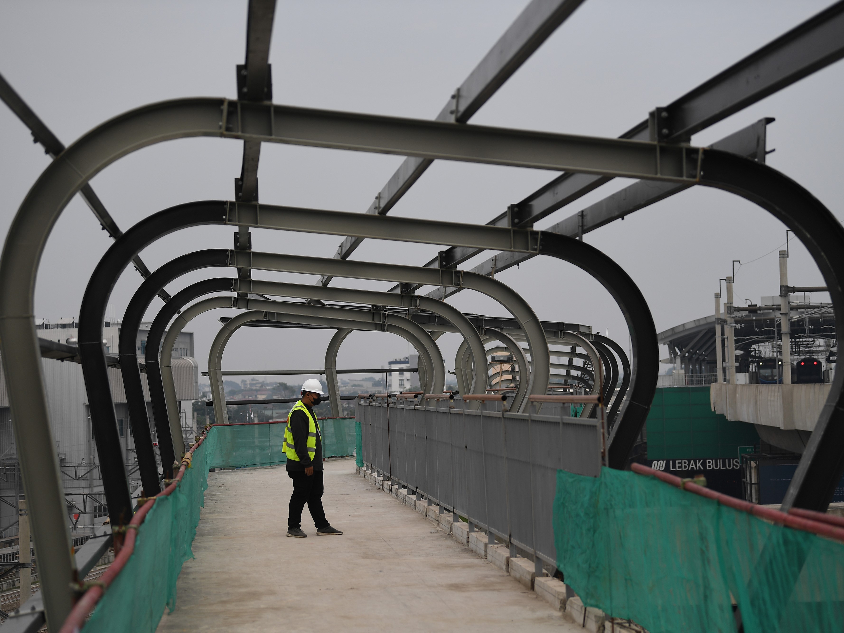 Seorang jurnalis mengamati proyek pembangunan Skywalk dan Plaza Transit Simpang Temu Lebak Bulus di Jakarta Selatan, Selasa (11/10/2022).
