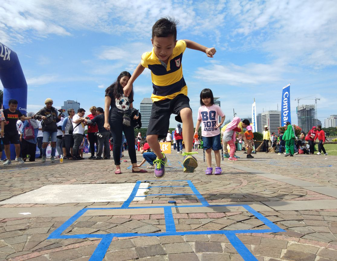 Anak-anak menikmati permainan tradisional pada kegiatan #JamMainKita di kawasan Monumen Nasional (Monas), Jakarta.