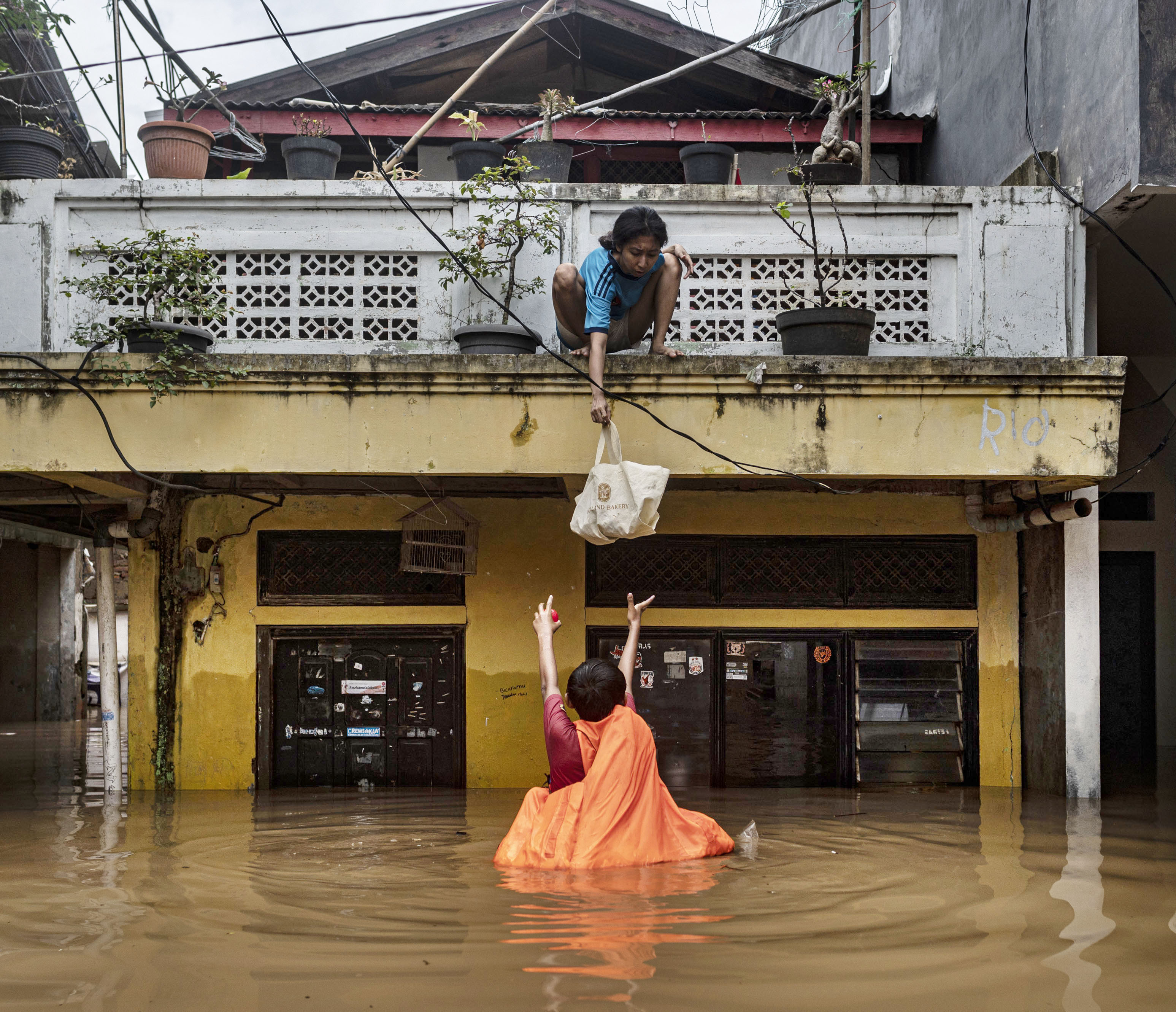 Warga menurunkan barang saat banjir di permukiman penduduk kawasan Rawajati, Jakarta, Senin (10/10).