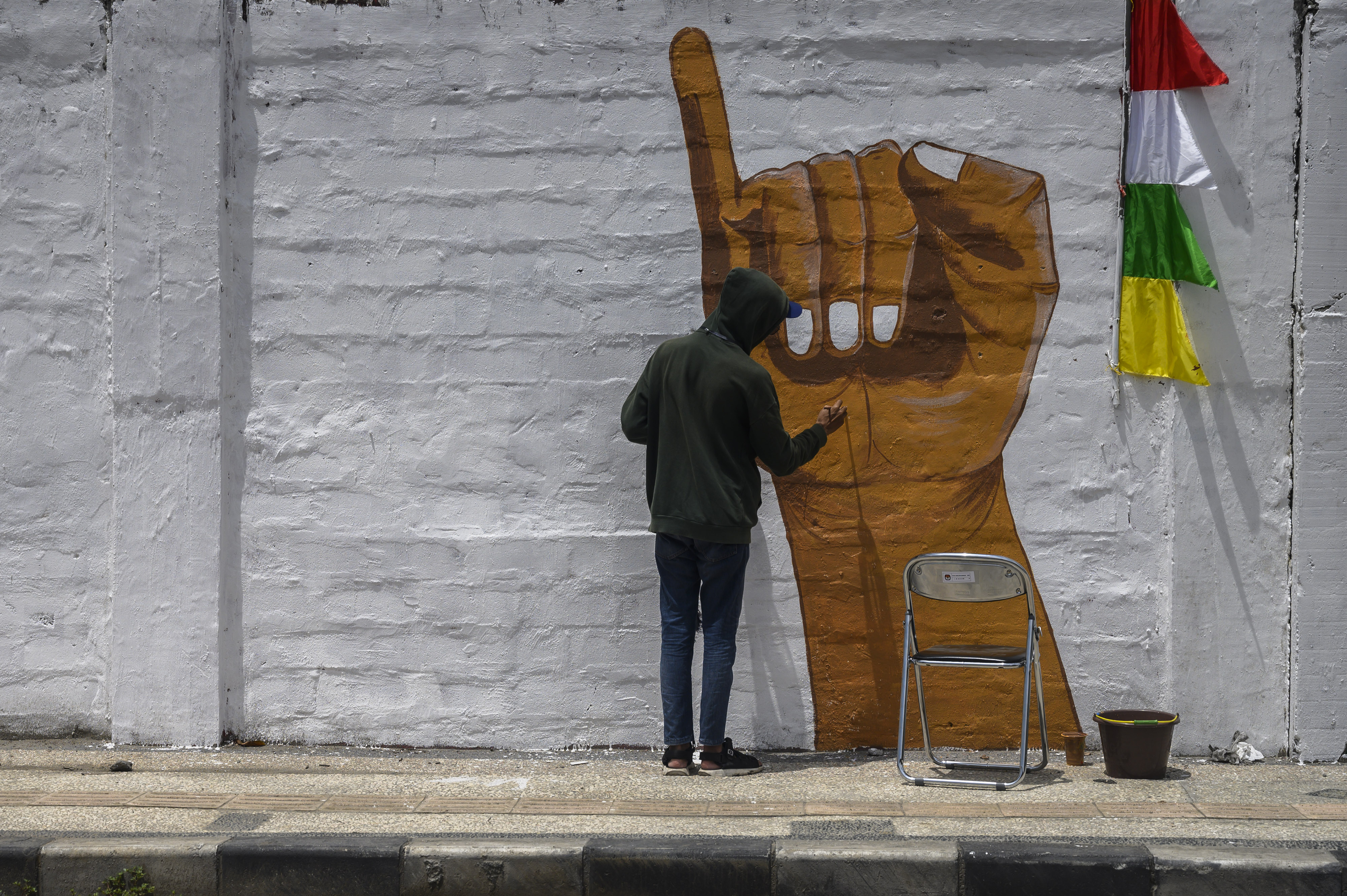 Potret seniman menyelesaikan mural terkait pemilu.