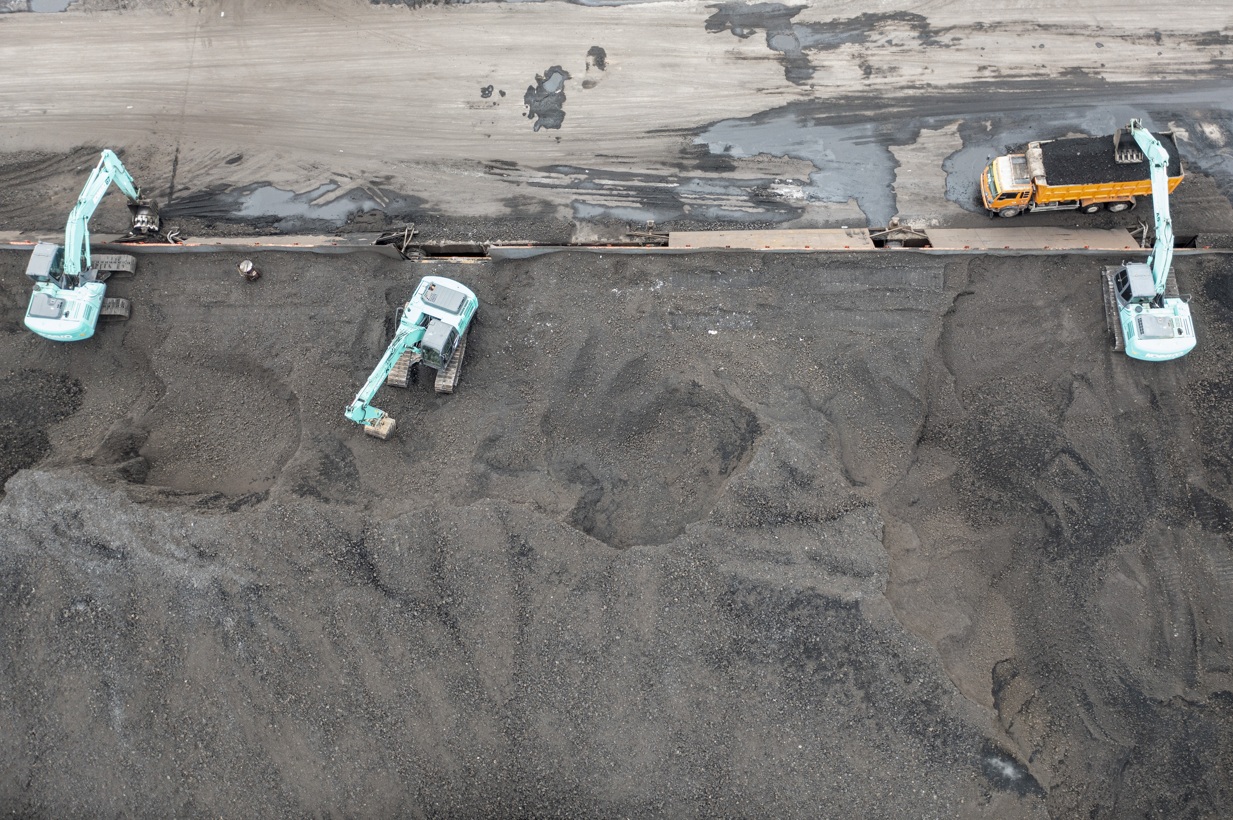 Pekerja mengoperasikan alat berat saat bongkar muat batu bara di kawasan Marunda, Jakarta.