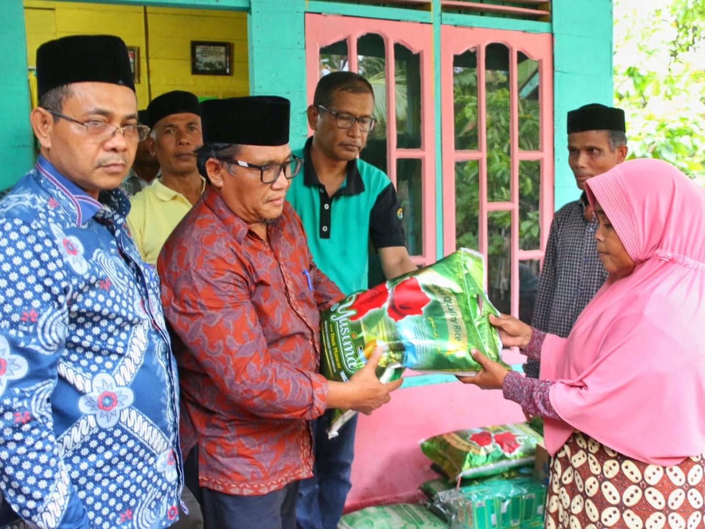 Penjabat Bupati Pidie Wahyudi Adisiswanto (baju batik merah) dan Sekda Idhami (baju batik biru) menyerahkan bantuan kepada istri M Affan.