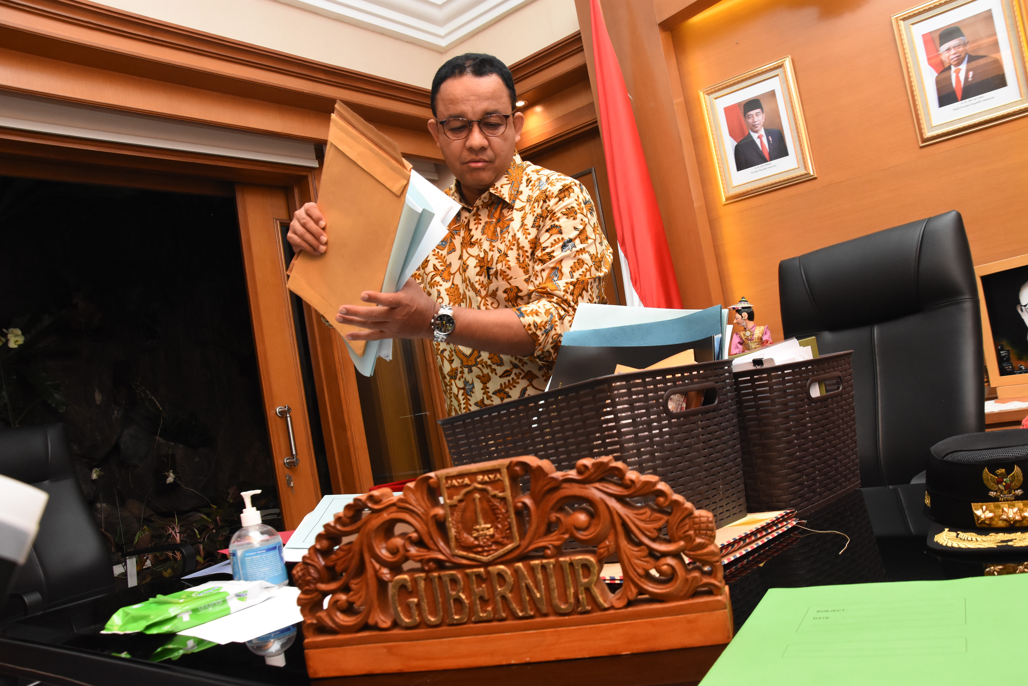 Gubernur DKI Jakarta Anies Baswedan merapikan berkas dan buku di ruang kerjanya.