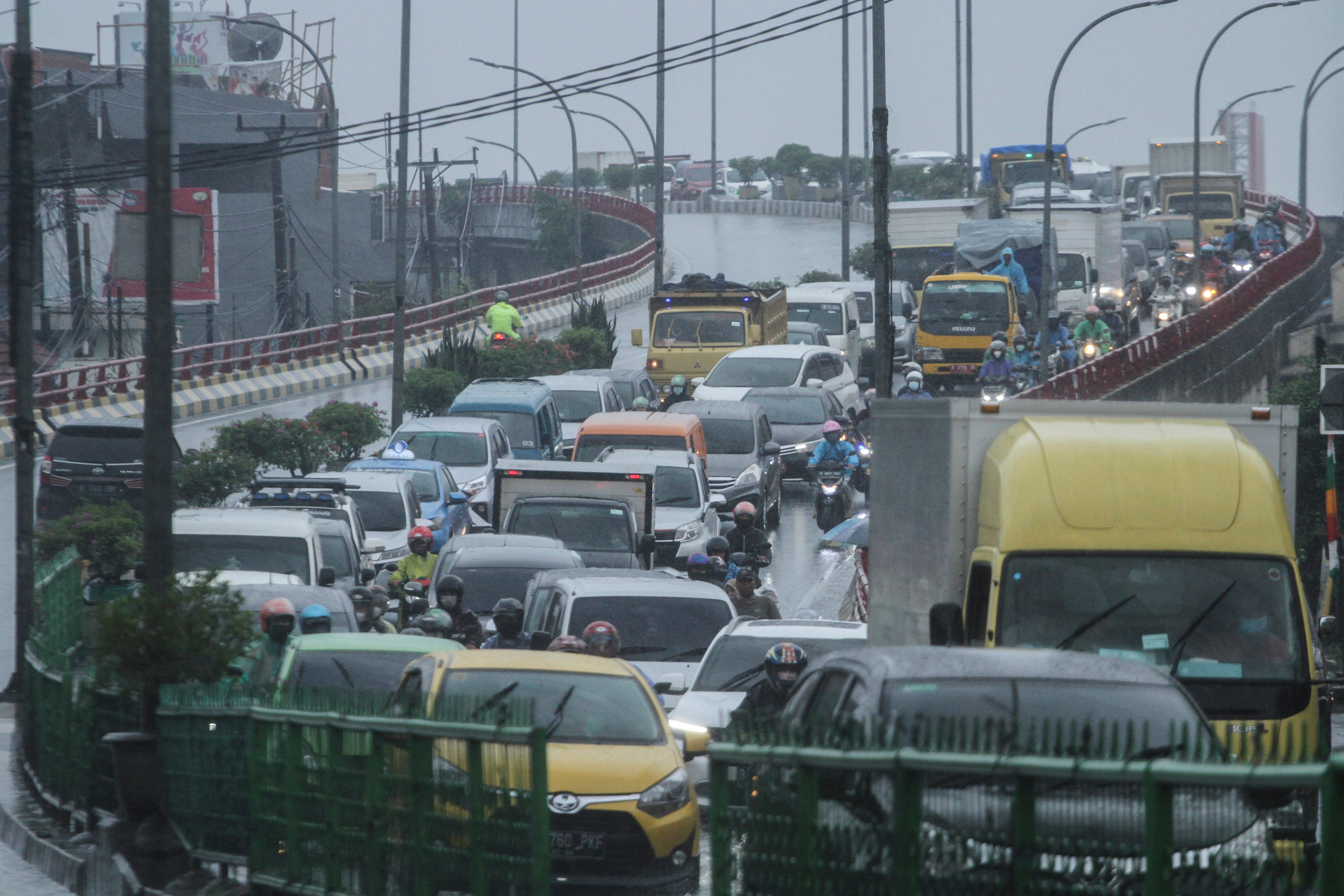 Sejumlah kendaraan mengantre untuk melintas akibat akses jalan yang terendam genangan air di Jalan Arif Rahman Hakim, Depok, Jawa Barat.