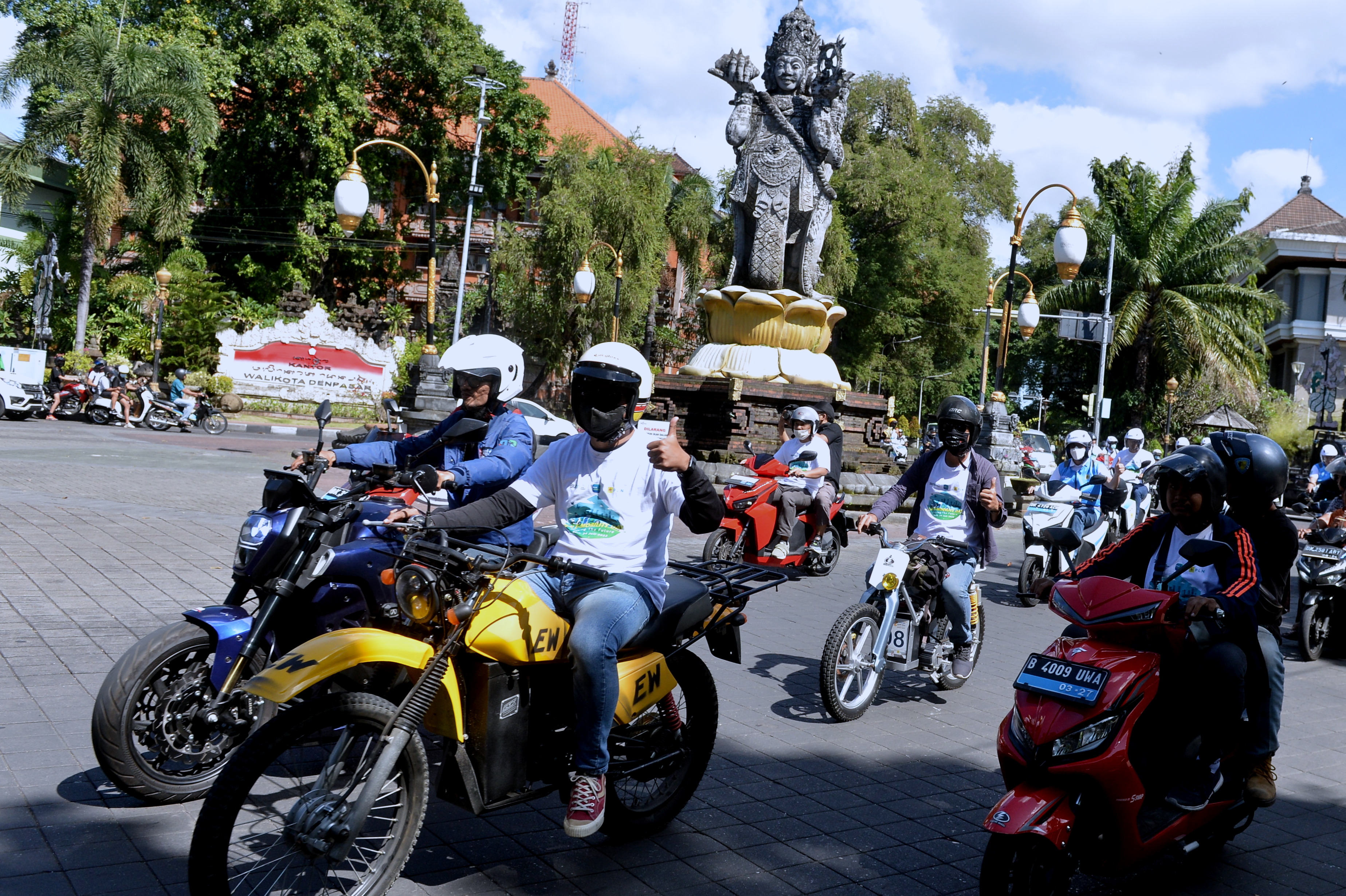 Sejumlah warga mengikuti konvoi kendaraan listrik saat kegiatan PLN E-Mobility Day: Driving The Future di Denpasar, Bali, Minggu (24/7).