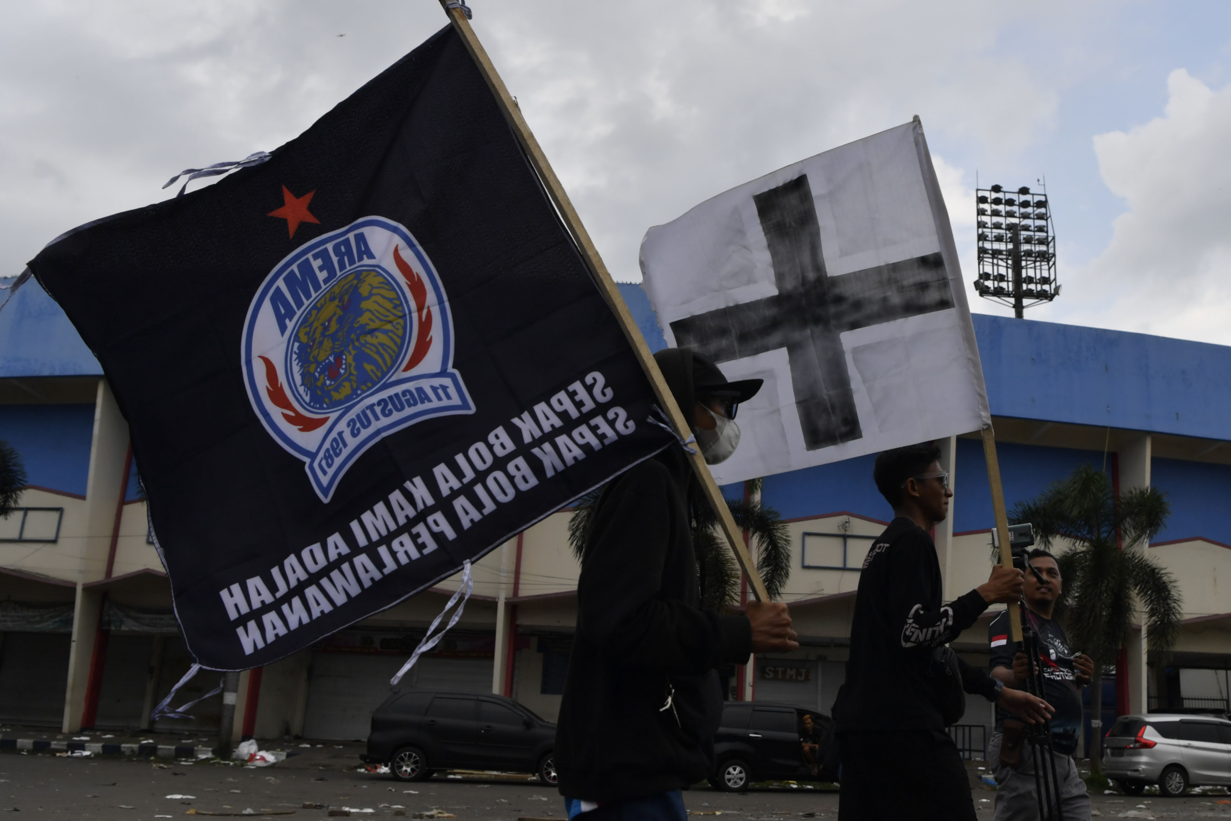 Suporter Arema FC (Aremania) membawa bendera di depan Stadion Kanjuruhan, Malang, Jawa Timur, Minggu (2/10).