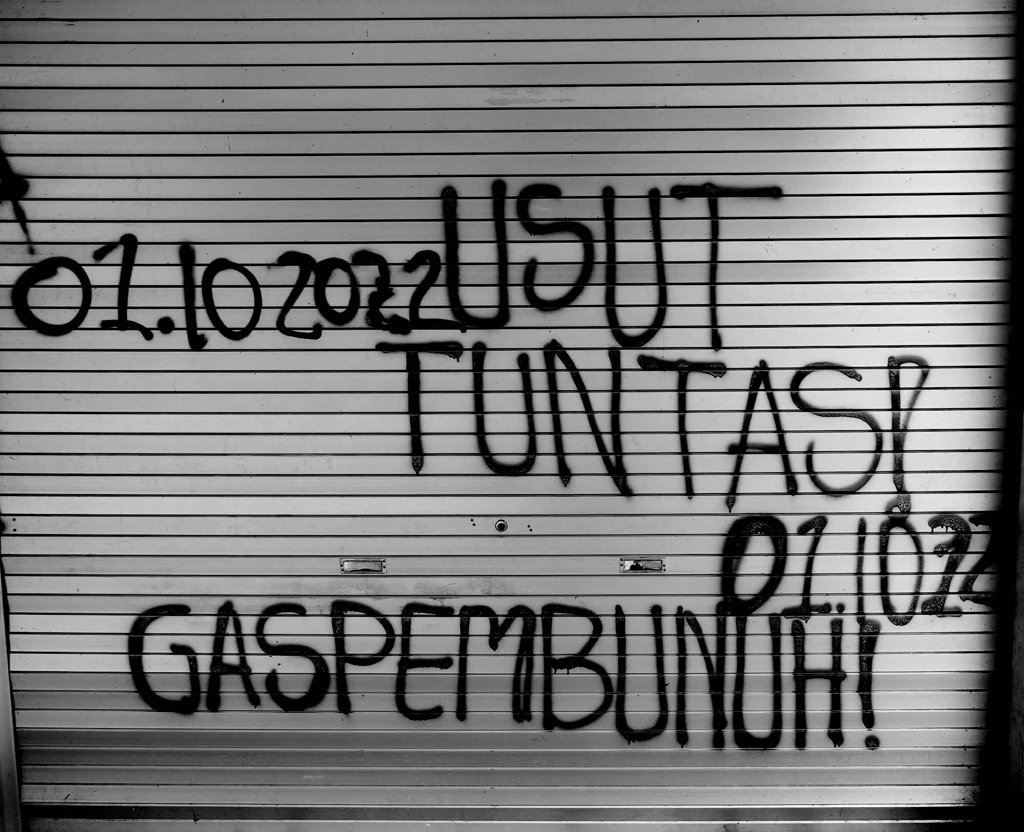 Coretan ‘usut tuntas dan gas pembunuh’ di rolling door warung yang berada di bawah tribune Stadion Kanjuruhan, Malang, Jatim.