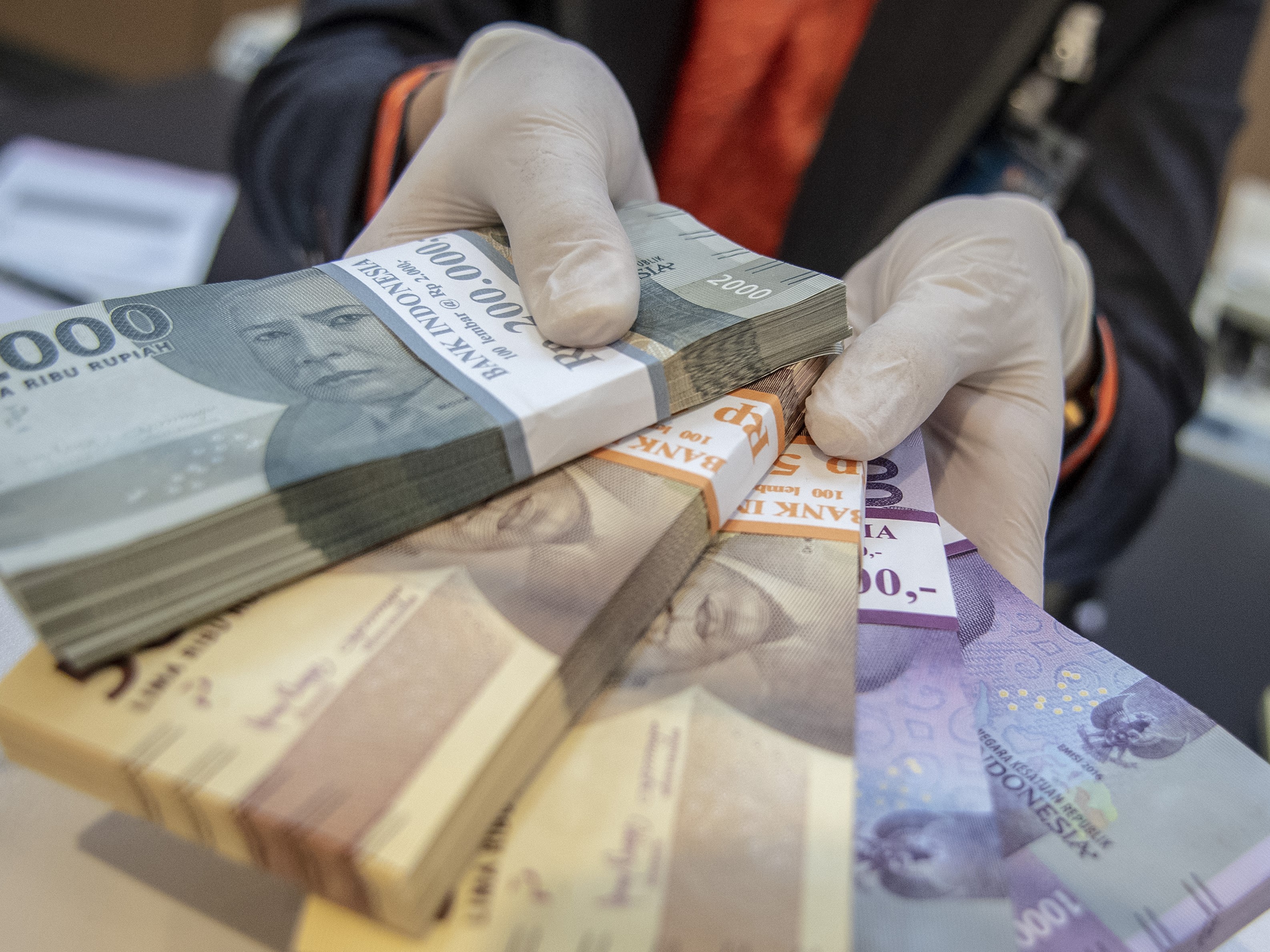 Petugas bank menunjukkan uang pecahan rupiah di BNI KC Mega Kuningan, Jakarta, Selasa (22/11/2022).