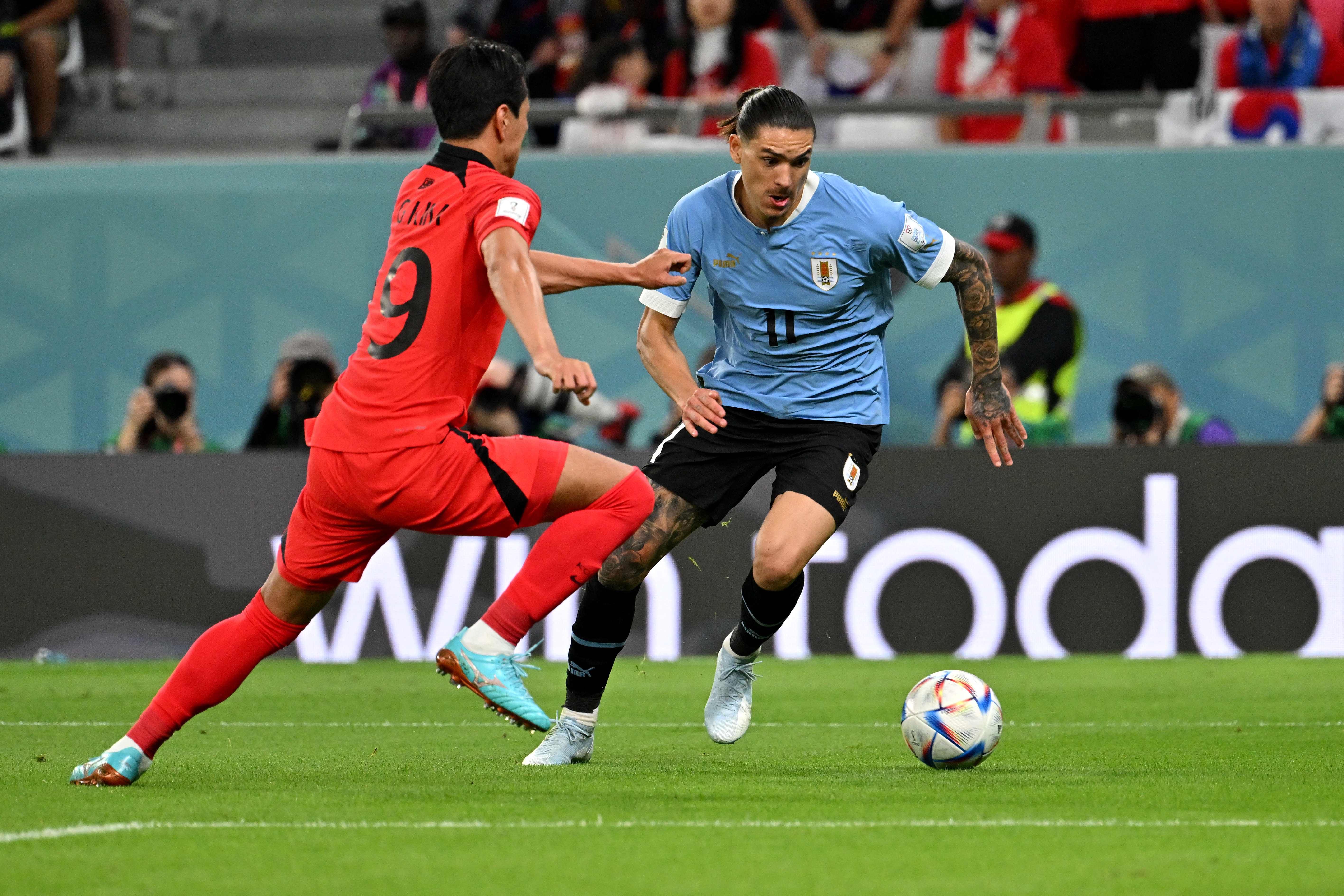Striker Uruguay, Darwin Nunez (kanan) berusaha melewati pemain Korsel dalam laga penyisihan Grup H Piala Dunia 2022, Kamis (24/11).
