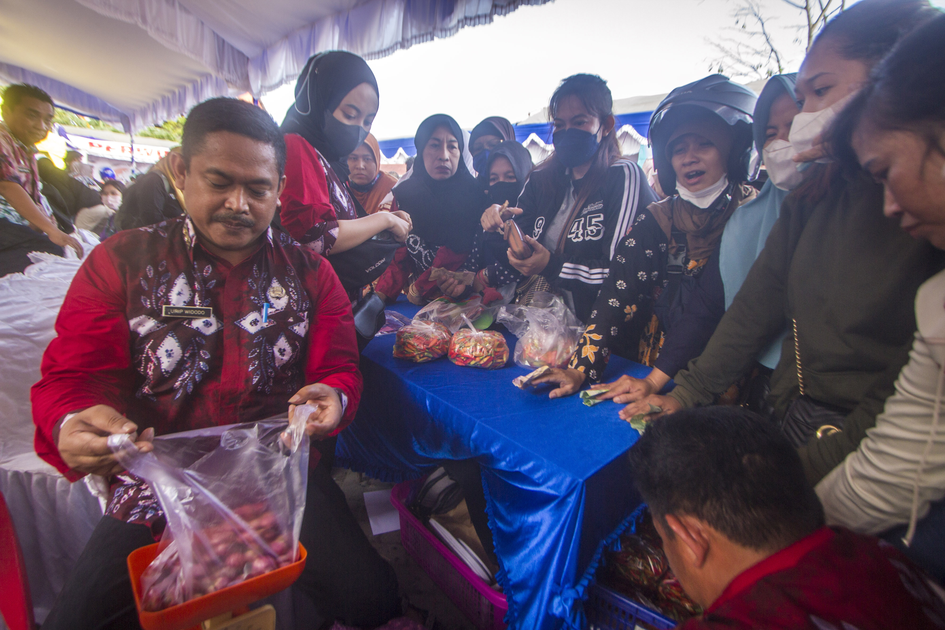 Sejumlah ASN melayani pembelian warga dalam pasar murah yang digelar Pemprov Kalsel guna menekan inflasi.