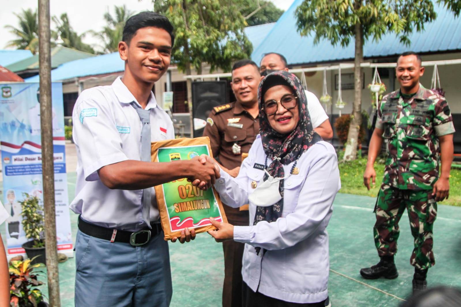 Wali Kota Pematang Siantar Susanti Dewayani (kanan) menyerahkan buku-buku bahan penguatan ideologi Pancasila kepada seorang perwakilan.