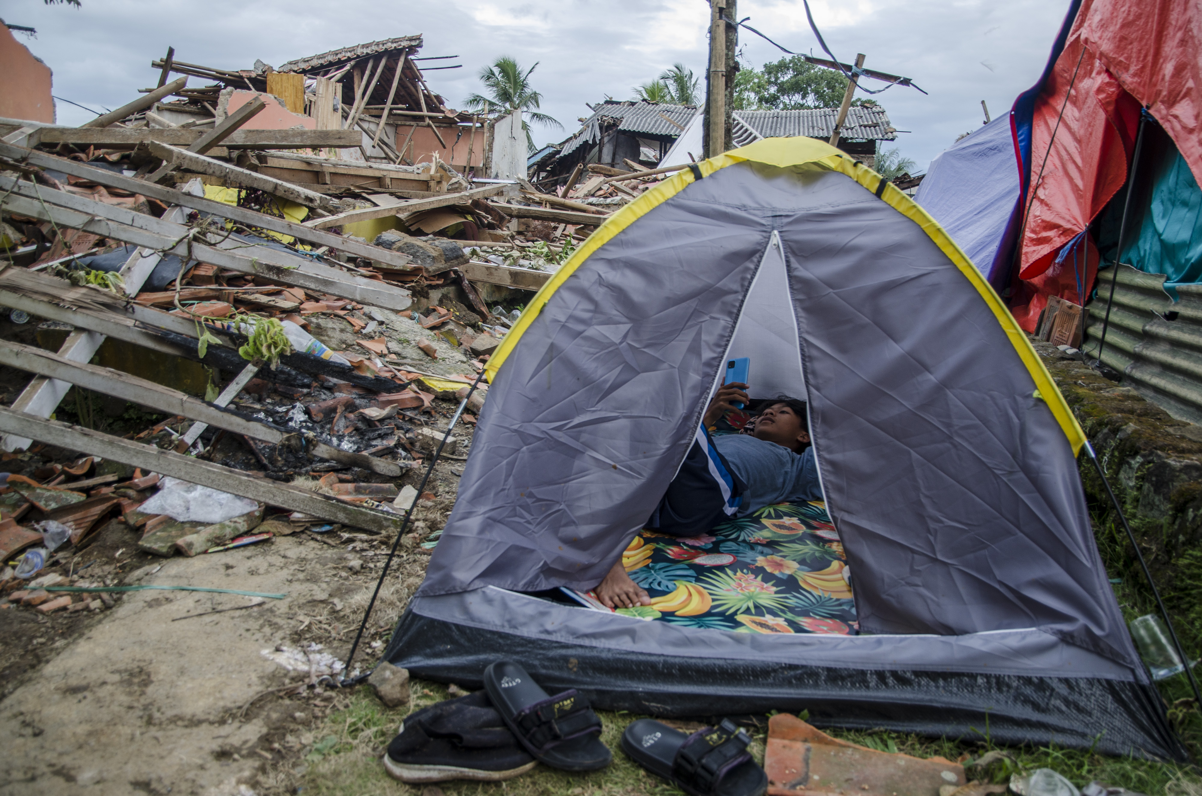 Warga beristirahat dalam tenda di sekitar reruntuhan rumah akibat gempa bumi di Gasol, Cianjur, Jawa Barat, Selasa (29/11).