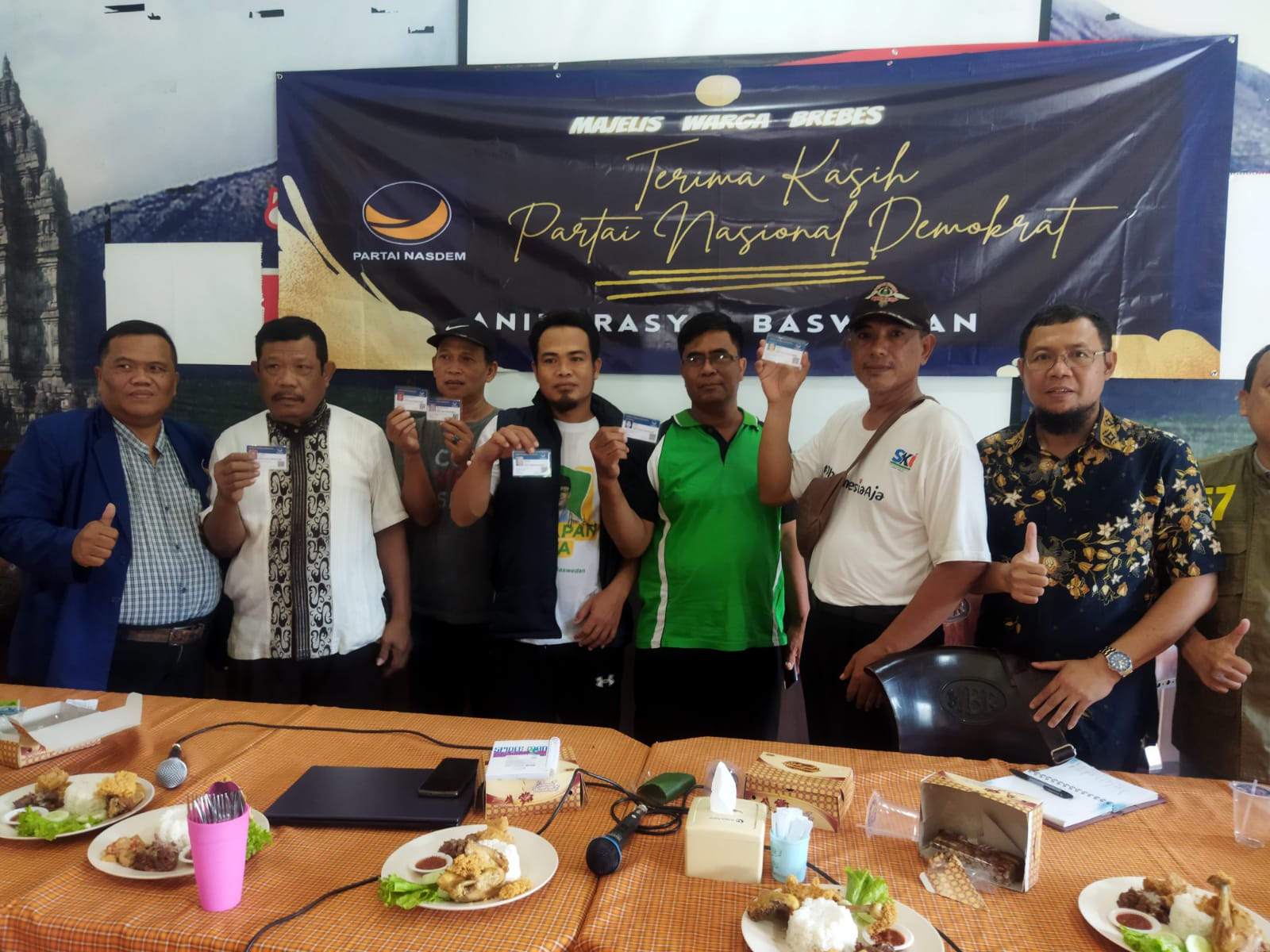 Warga yang bergabung dengan Partai Nasdem di Brebes secara simbolis menunjukkan Kartua anggota (KTA) Partai Nasdem. 